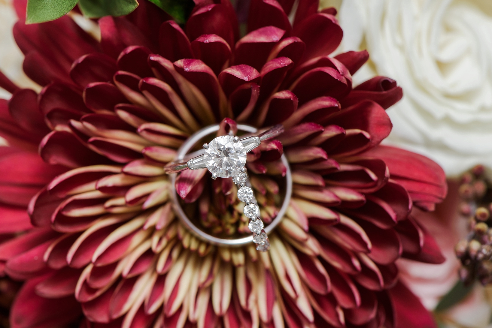 The wedding rings against the florals of the bride's bouquet