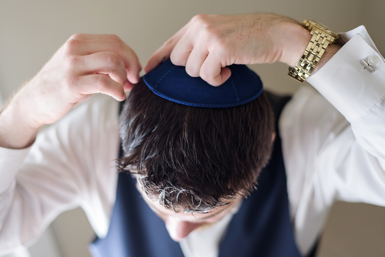 Groom putting his yarmulke on before his wedding
