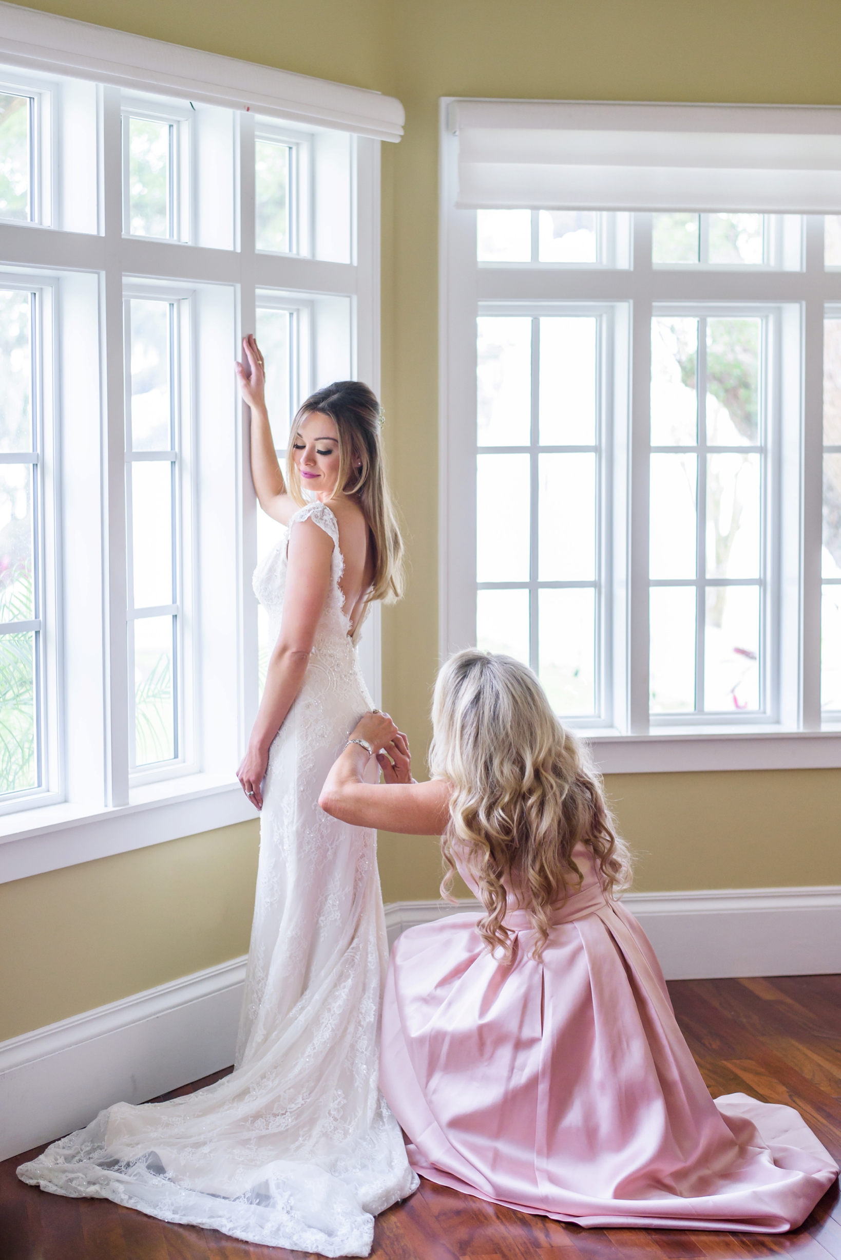 Bride's mother helping her daughter into her dress