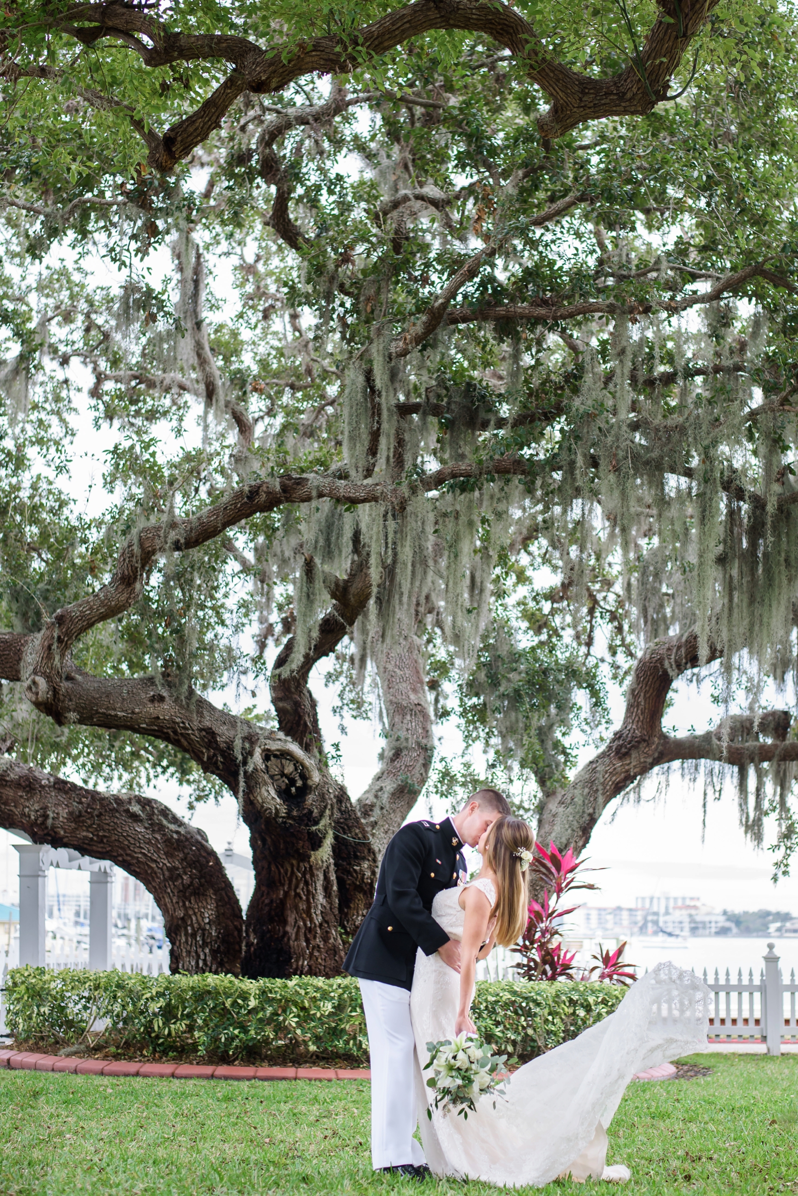 Bride and Groom kissing under a large Oak tree by Sarah & ben Photography