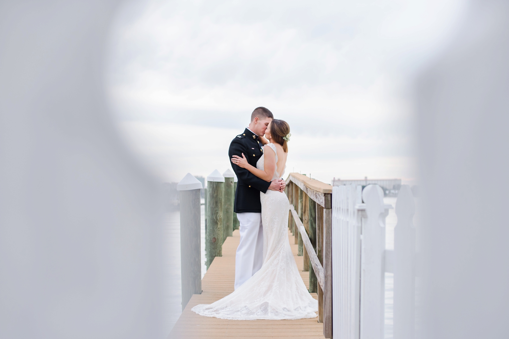 Bride and Groom kissing on the dock by Sarah & Ben Photography