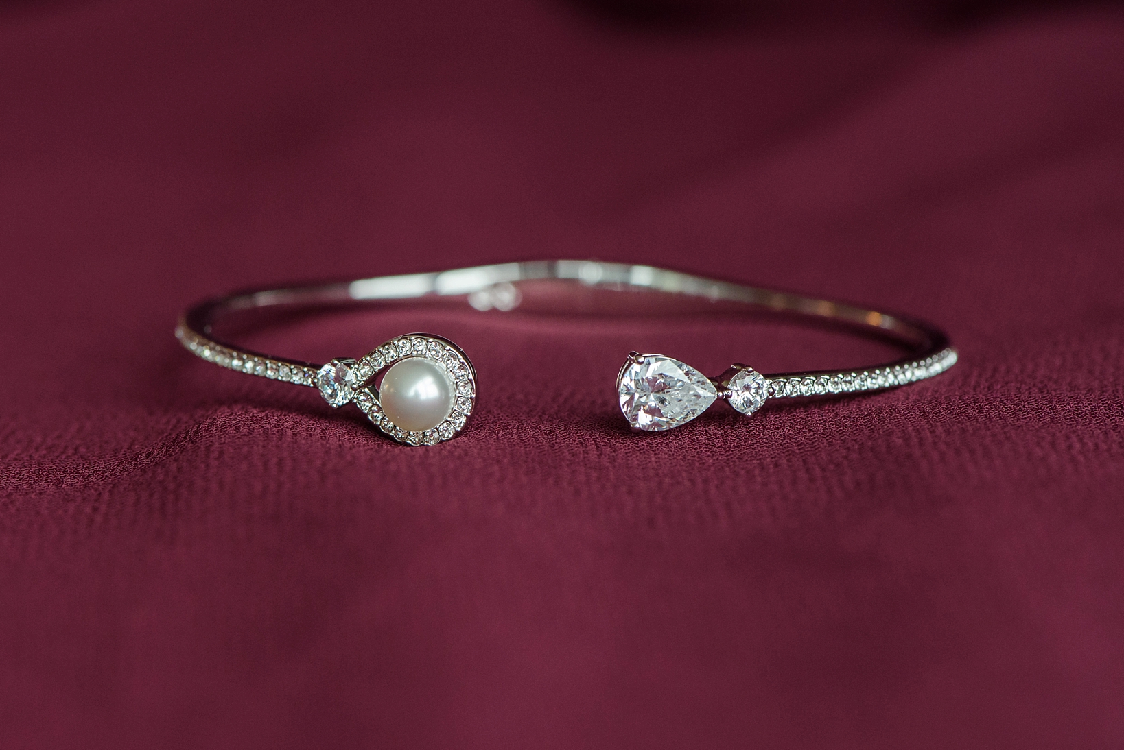 Bride's pearl and diamond bracelet against a merlot dress