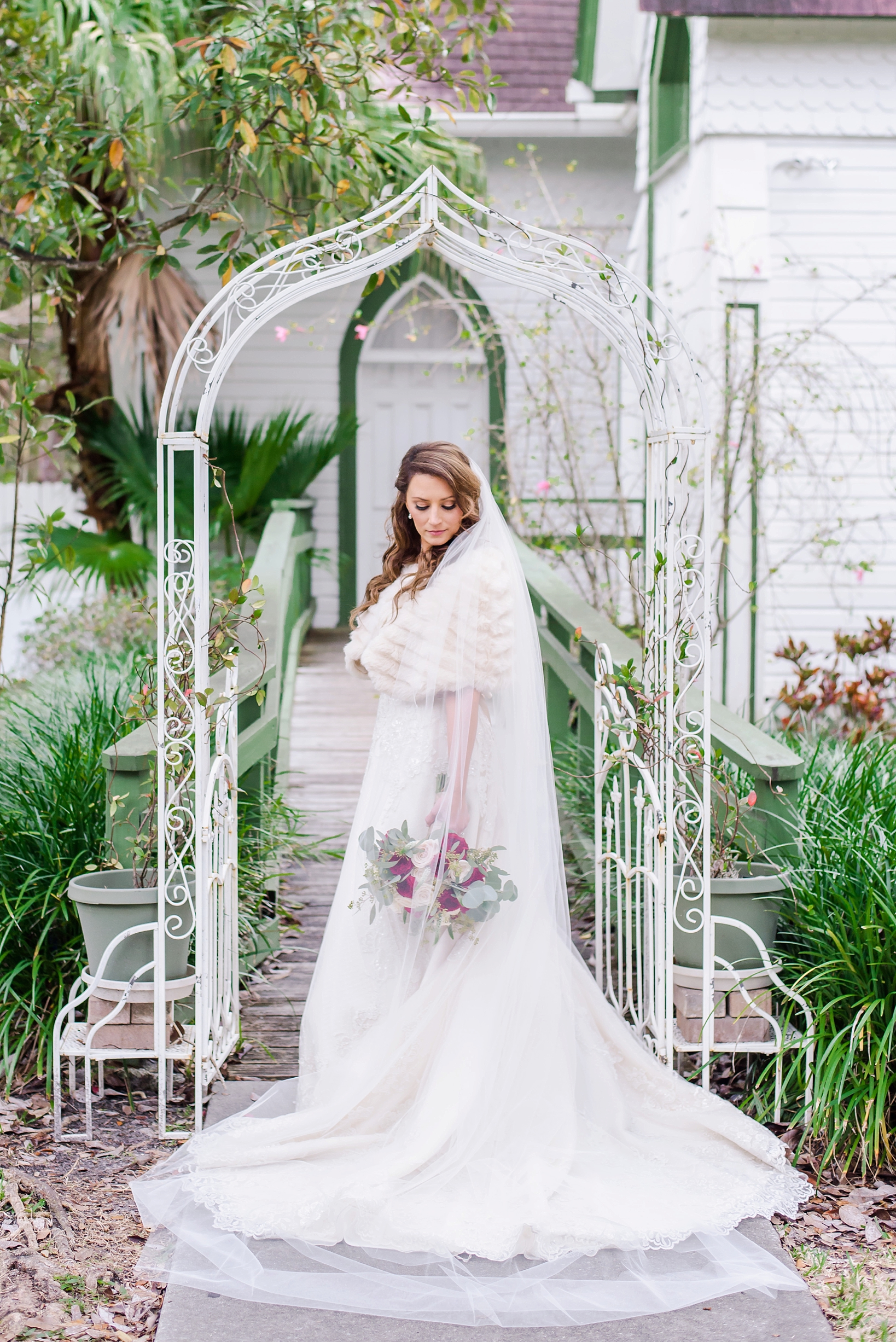 The bride wearing her faux fur wrap on a cold wedding day in front of the Andrews Memorial Chapel in Dunedin, FL