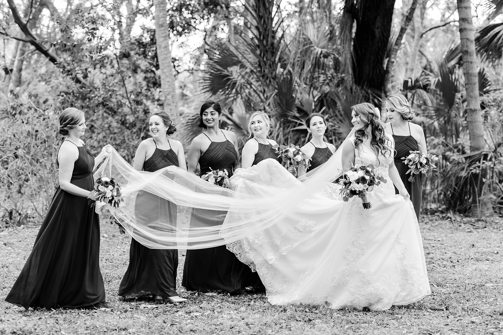 Black and White photo of the Bride and her Bridesmaids walking through the rustic woods in dunedin, FL