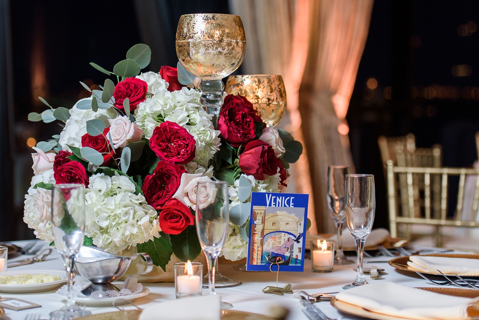 Wedding reception details including floral centerpieces and travel themed table numbers