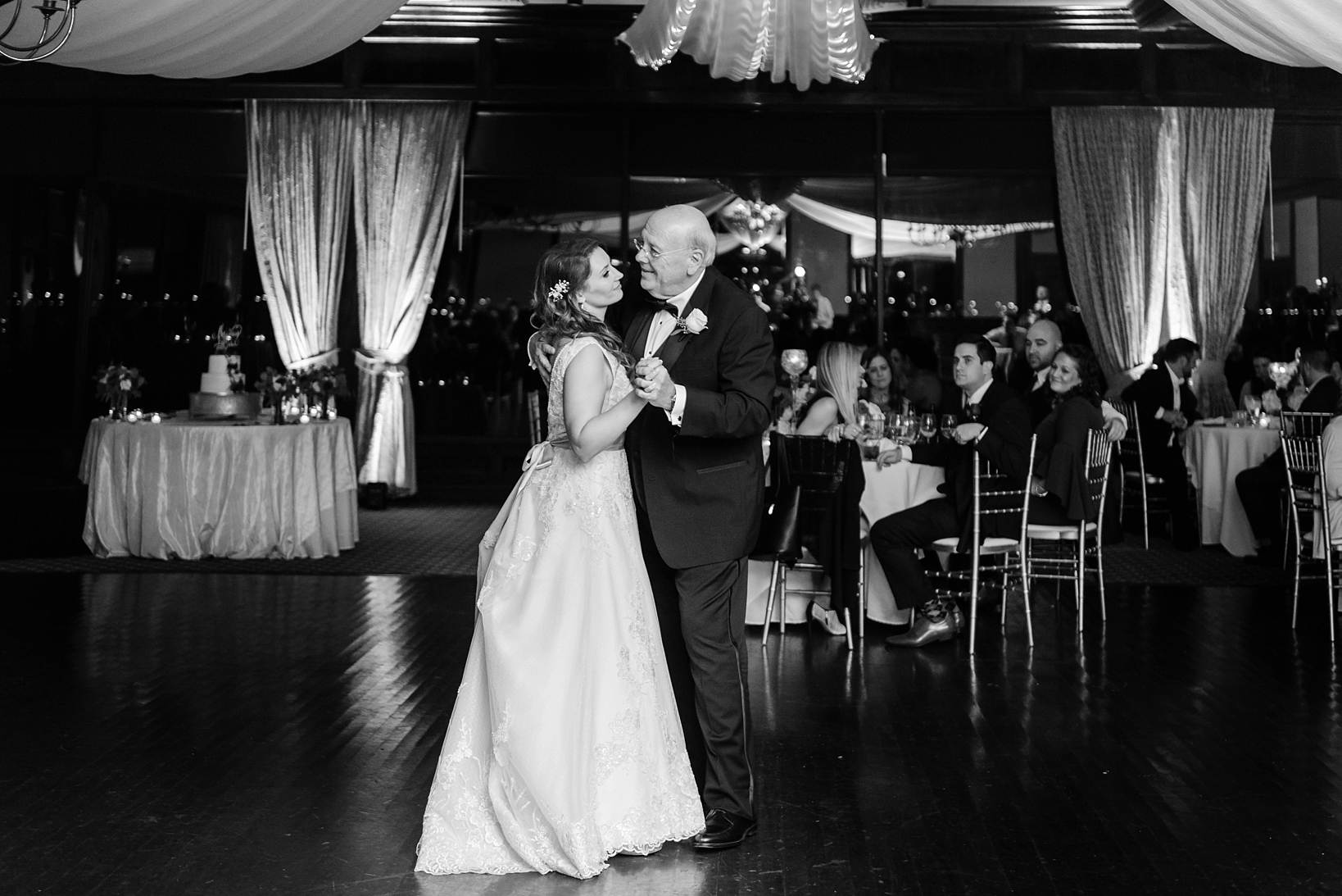 Black and white photo of a father dancing with his daughter on her wedding day