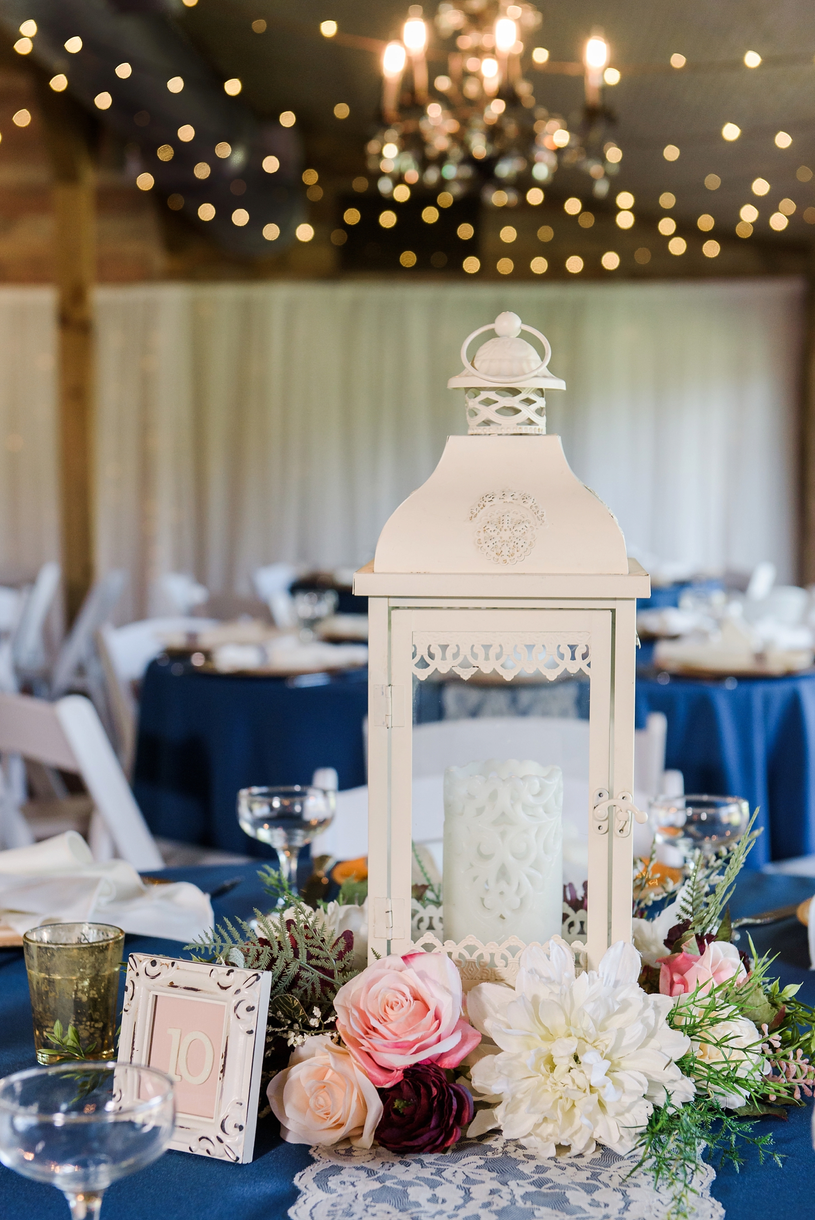 A candleholder centerpiece with floral accents on a navy tablecloth