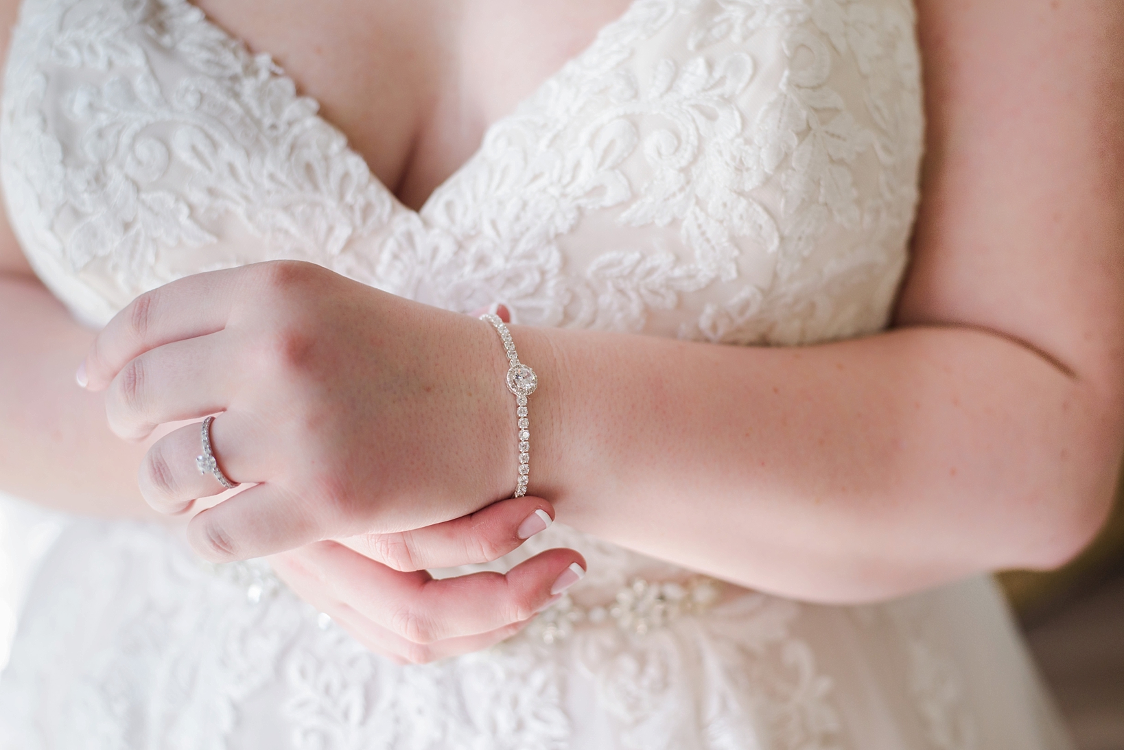 Bridal jewelry against the white lace of the wedding dress
