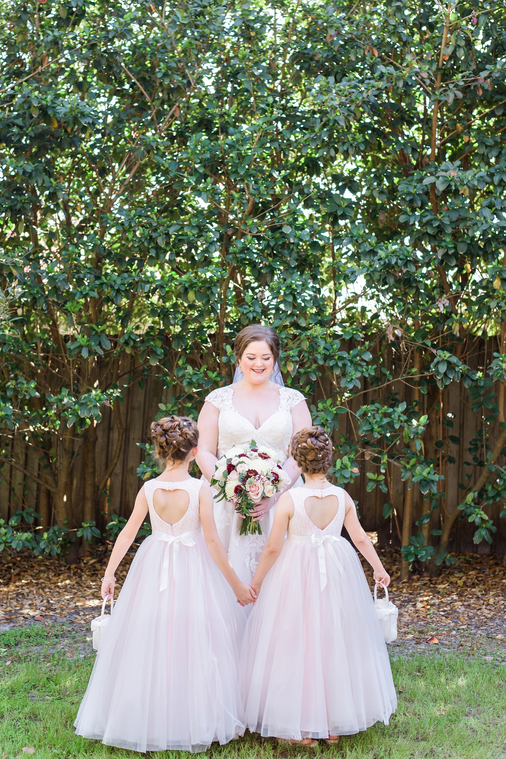 Bride and her flower girls in matching dresses with hearts in the back