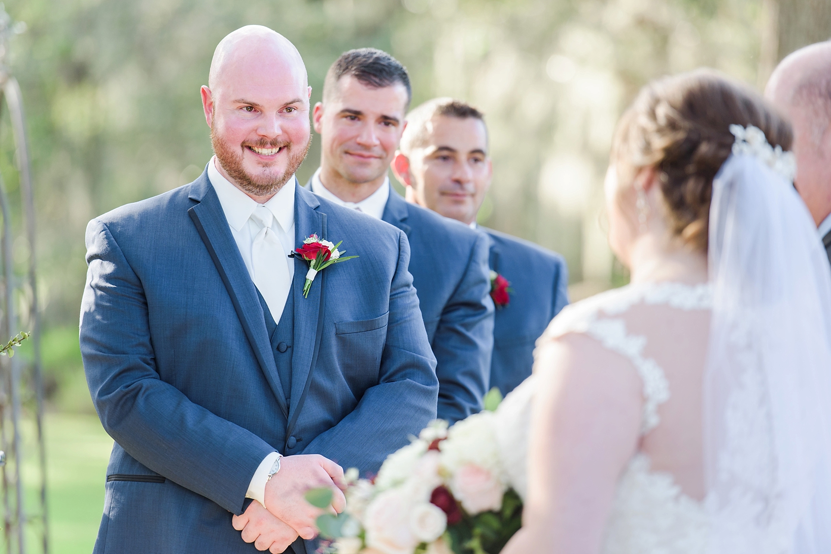 Groom smiling at his bride as she makes her way down the aisle
