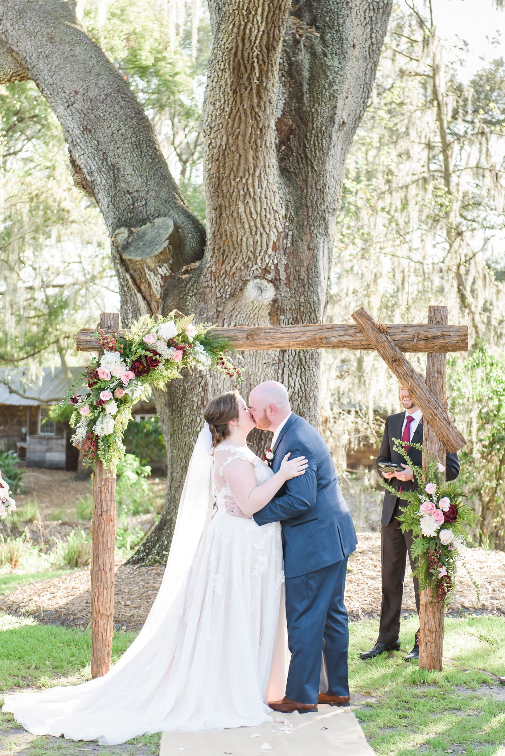 First Kiss with floral wedding altar