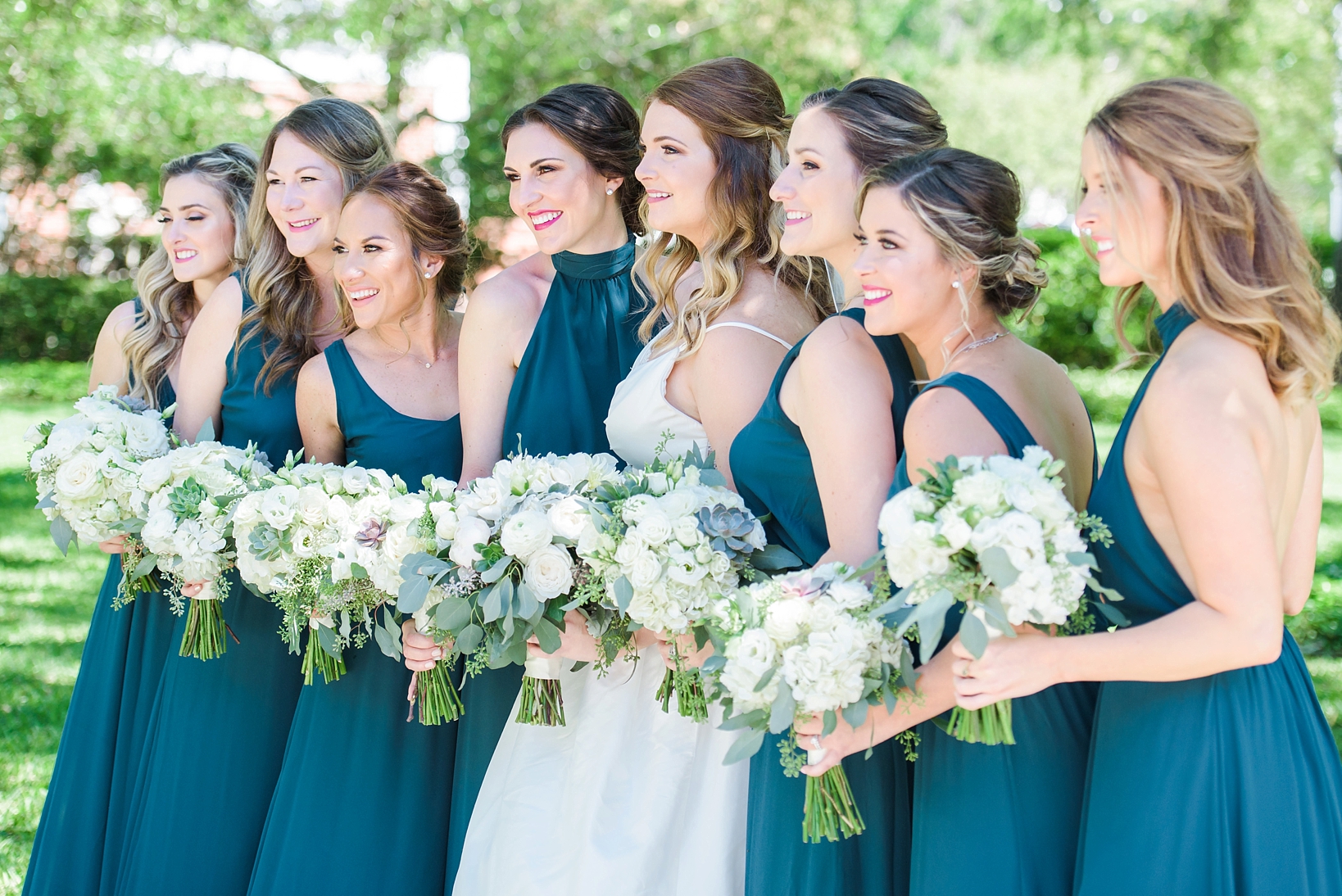 Bride with her bridesmaids wearing teal matching dresses