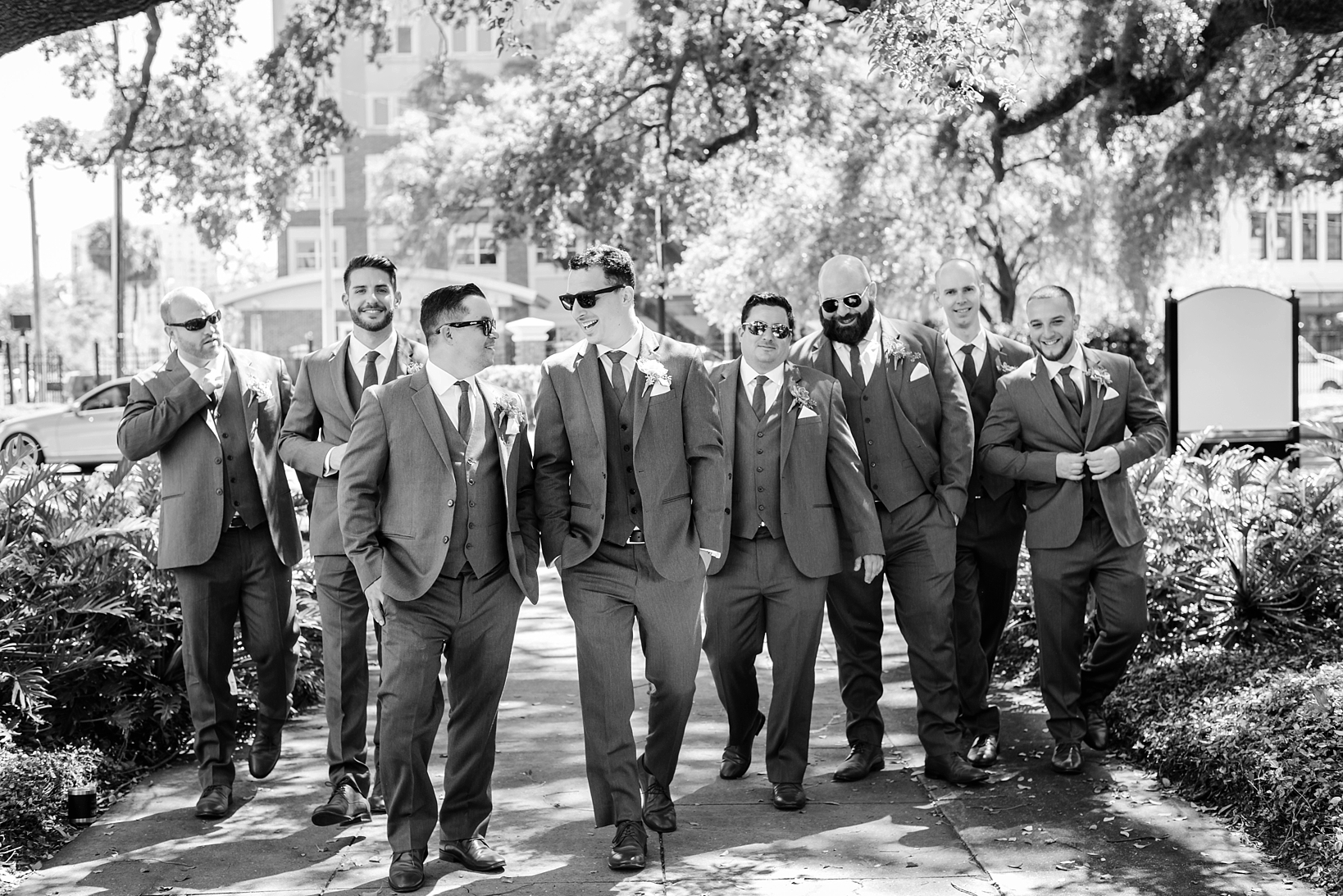 Groom and his Groomsmen walking in their matching suits by Sarah & Ben Photography