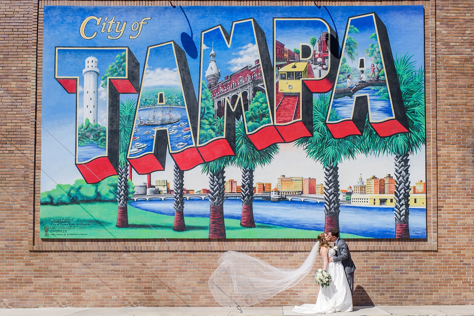 Bride and Groom kissing under the Tampa mural