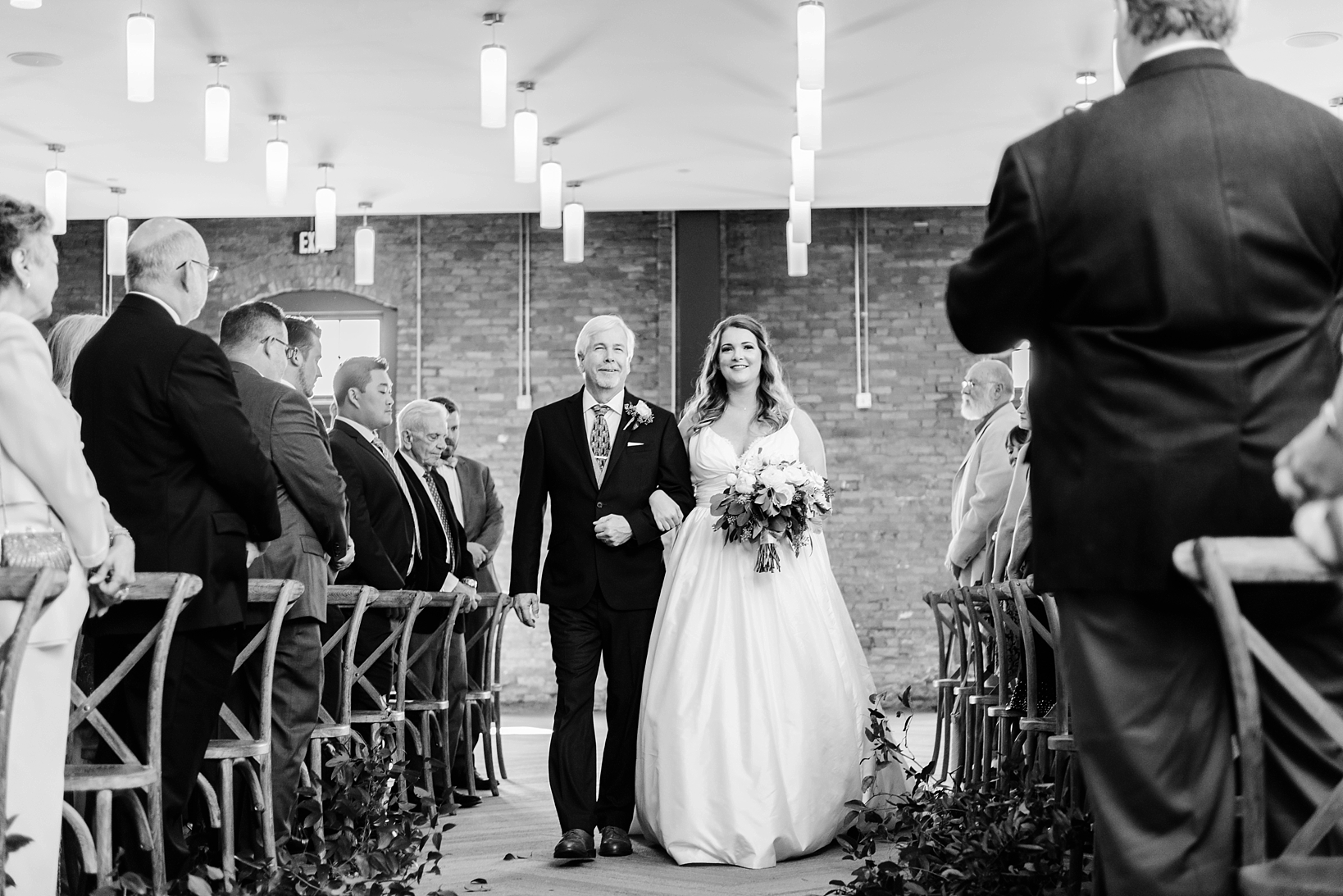 Bride and her father walking down the aisle in the social room of Armature Works by Sarah & Ben Photography