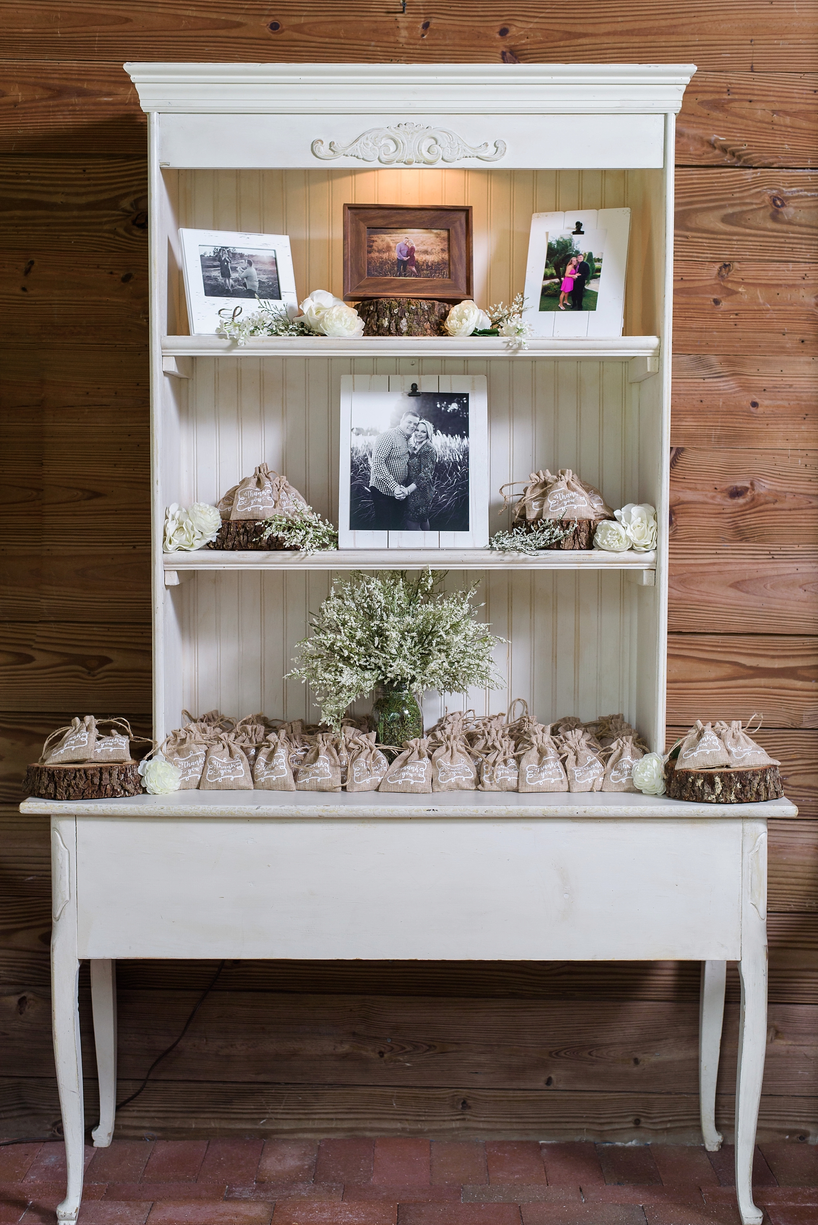 Thank you gifts and family photos on an antique vanity in the reception barn