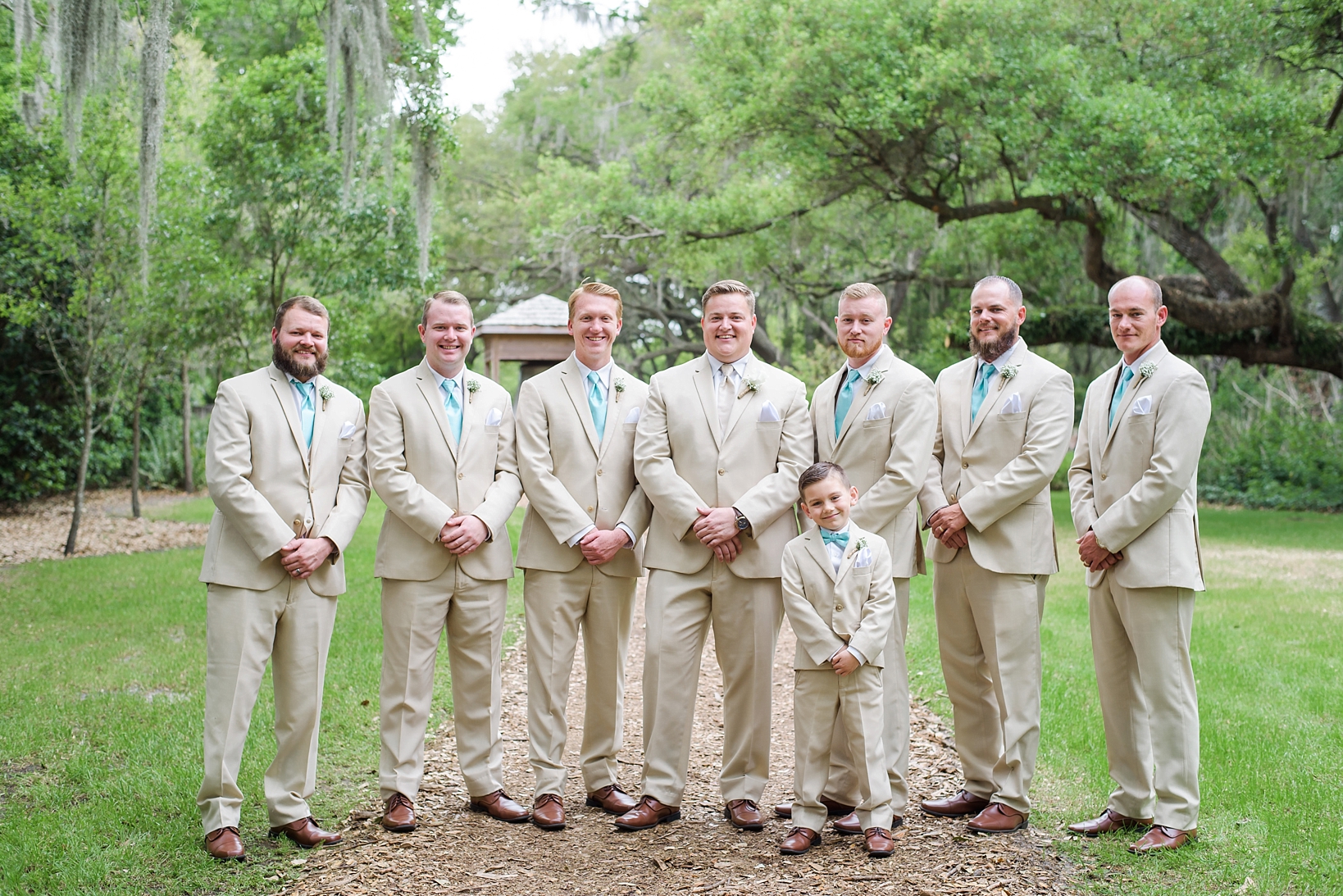 The groom and his groomsmen in cream suits with tiffany blue ties