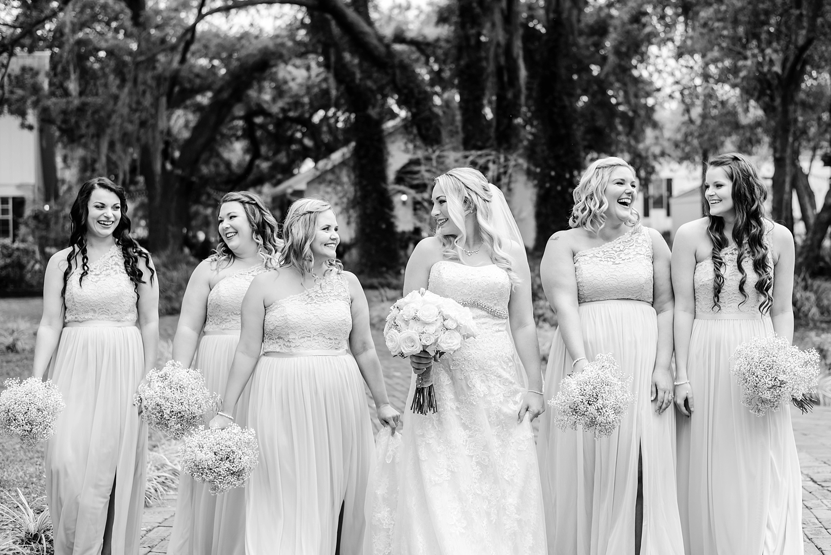 Bride and her bridesmaids laughing in black and white