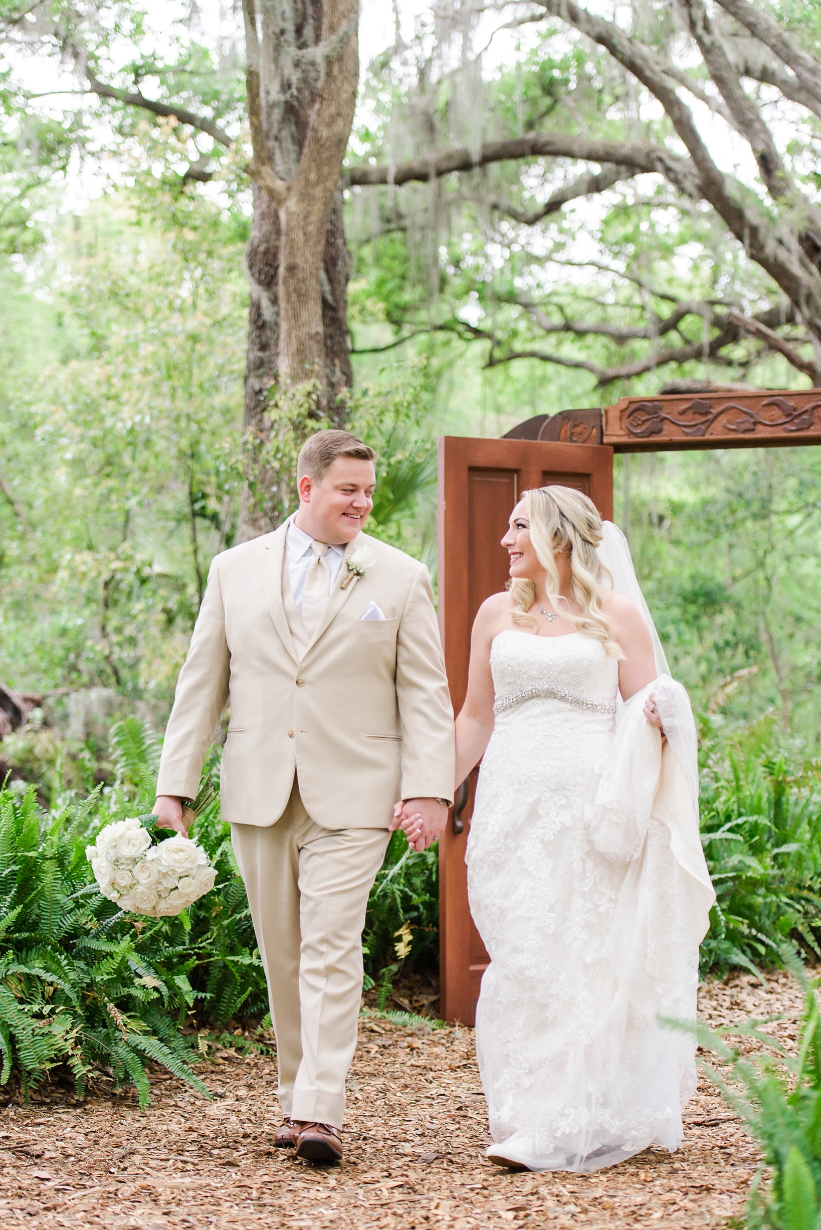 Bride and Groom walking in the enchanted forest towards the cross creek ranch reception