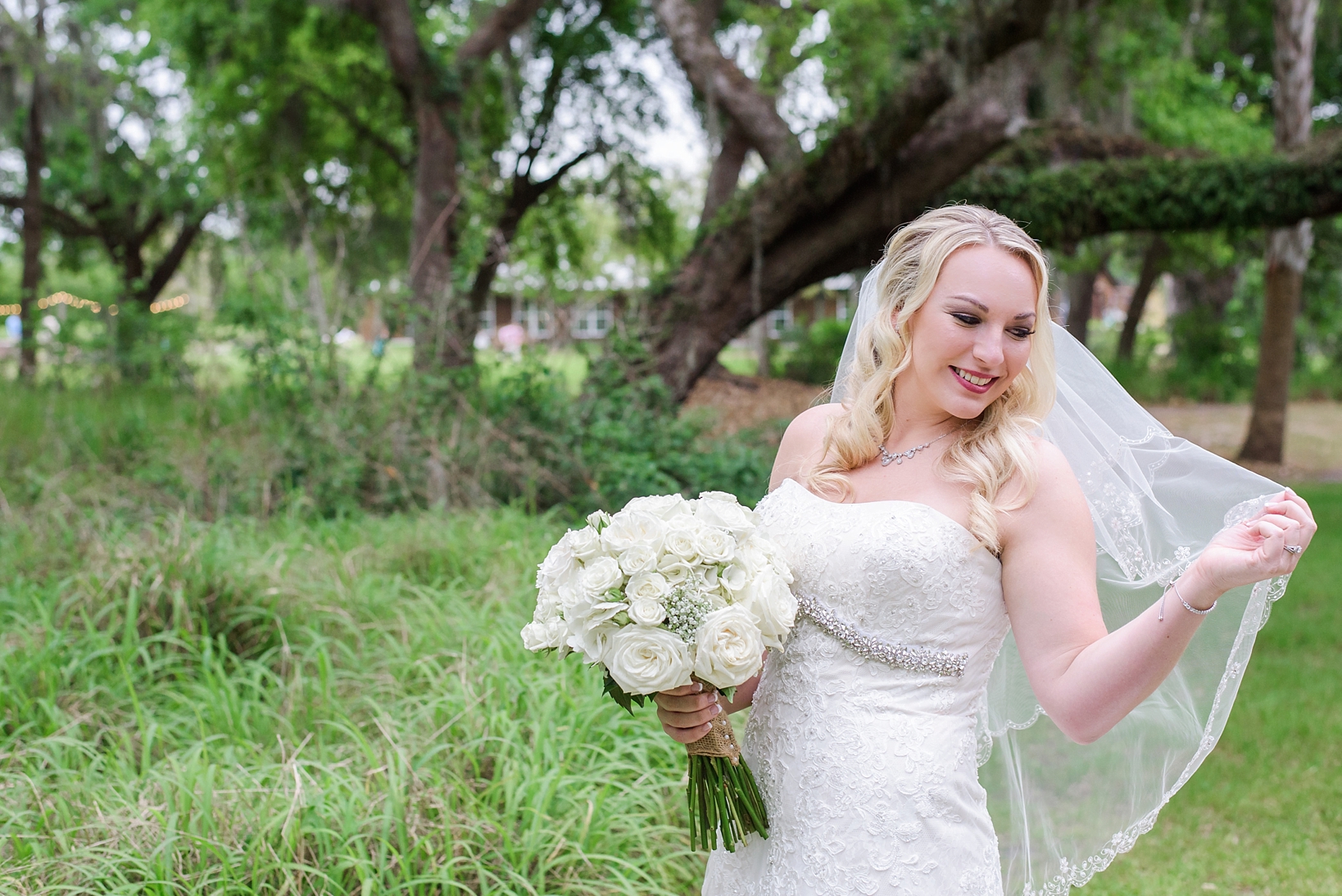 Bride holding her veil and white rose bouquet in Tampa, FL