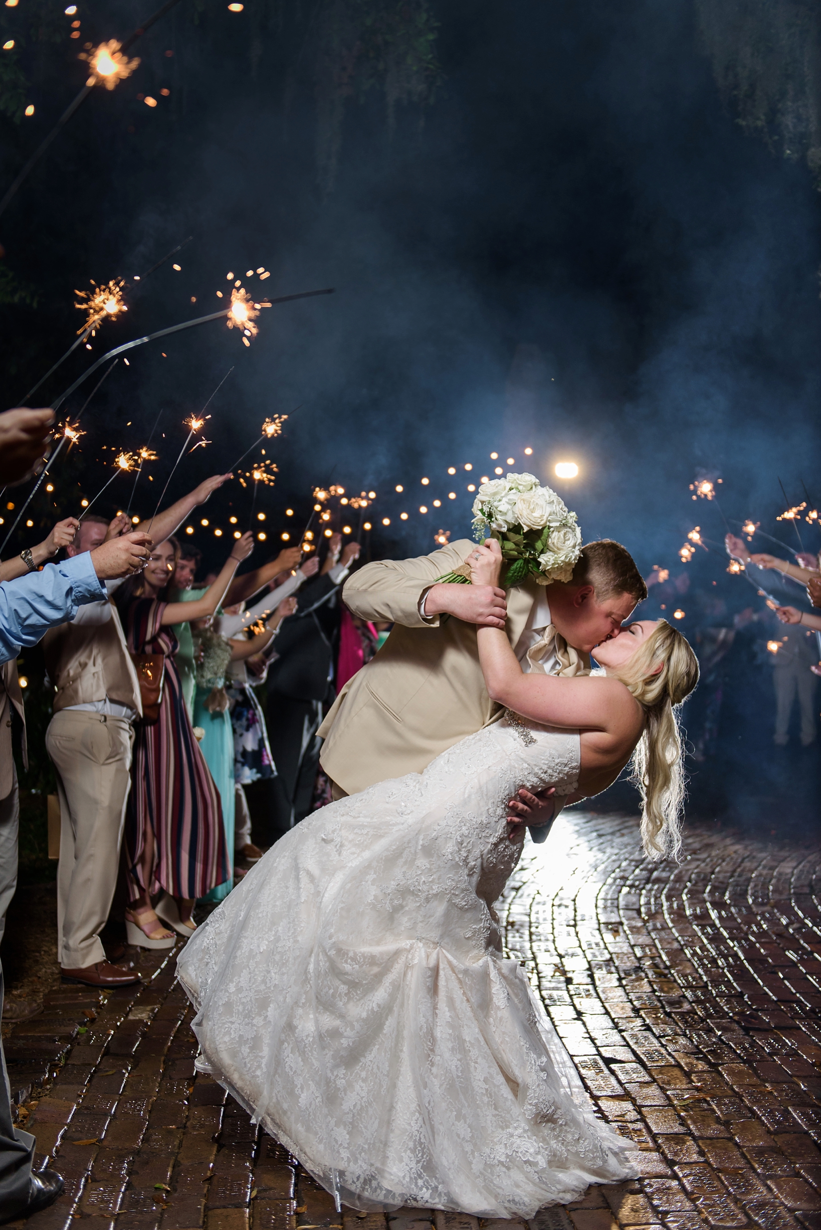 Groom dips bride during the sparkler exit from their cross creek ranch reception