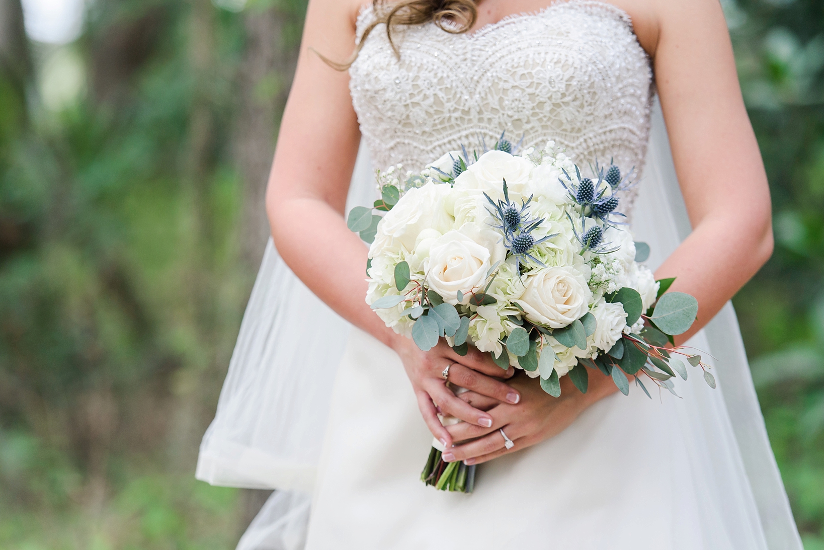 The bride's rose filled bouquet against her wedding dress by Sarah & Ben Photography