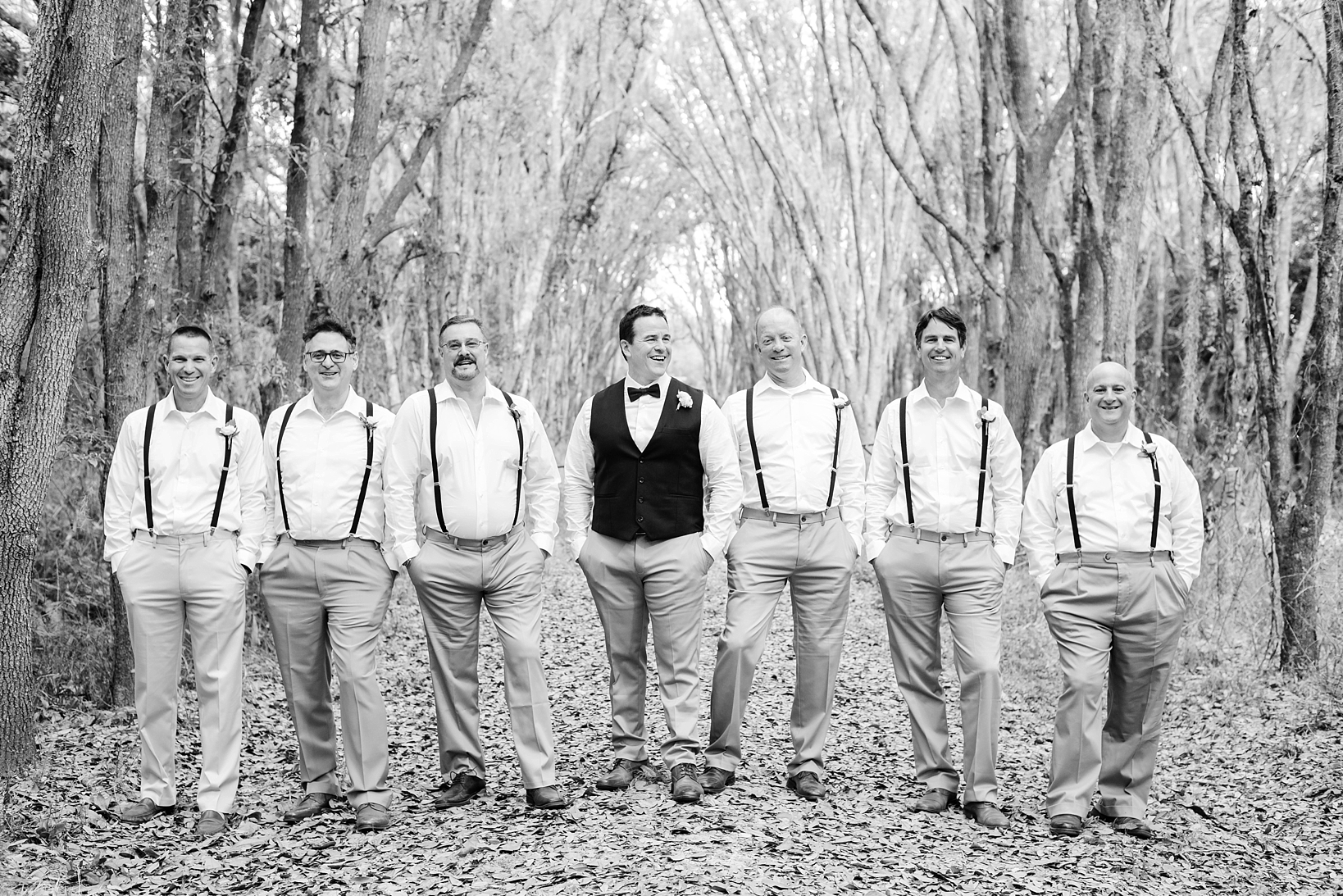 Groom with his groomsmen in a tunnel of the old oak trees
