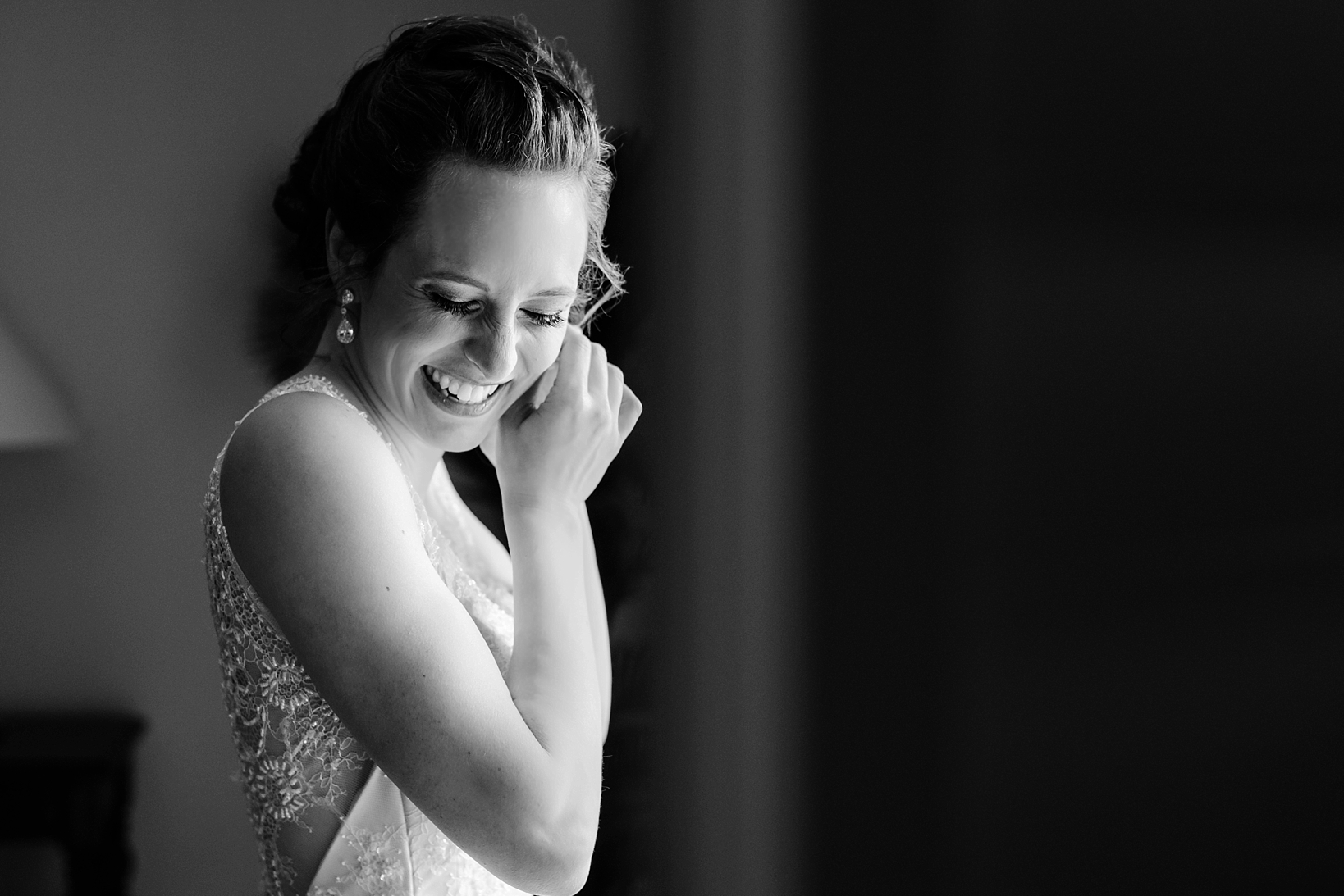 Bride laughing to herself in a timeless black and white photo