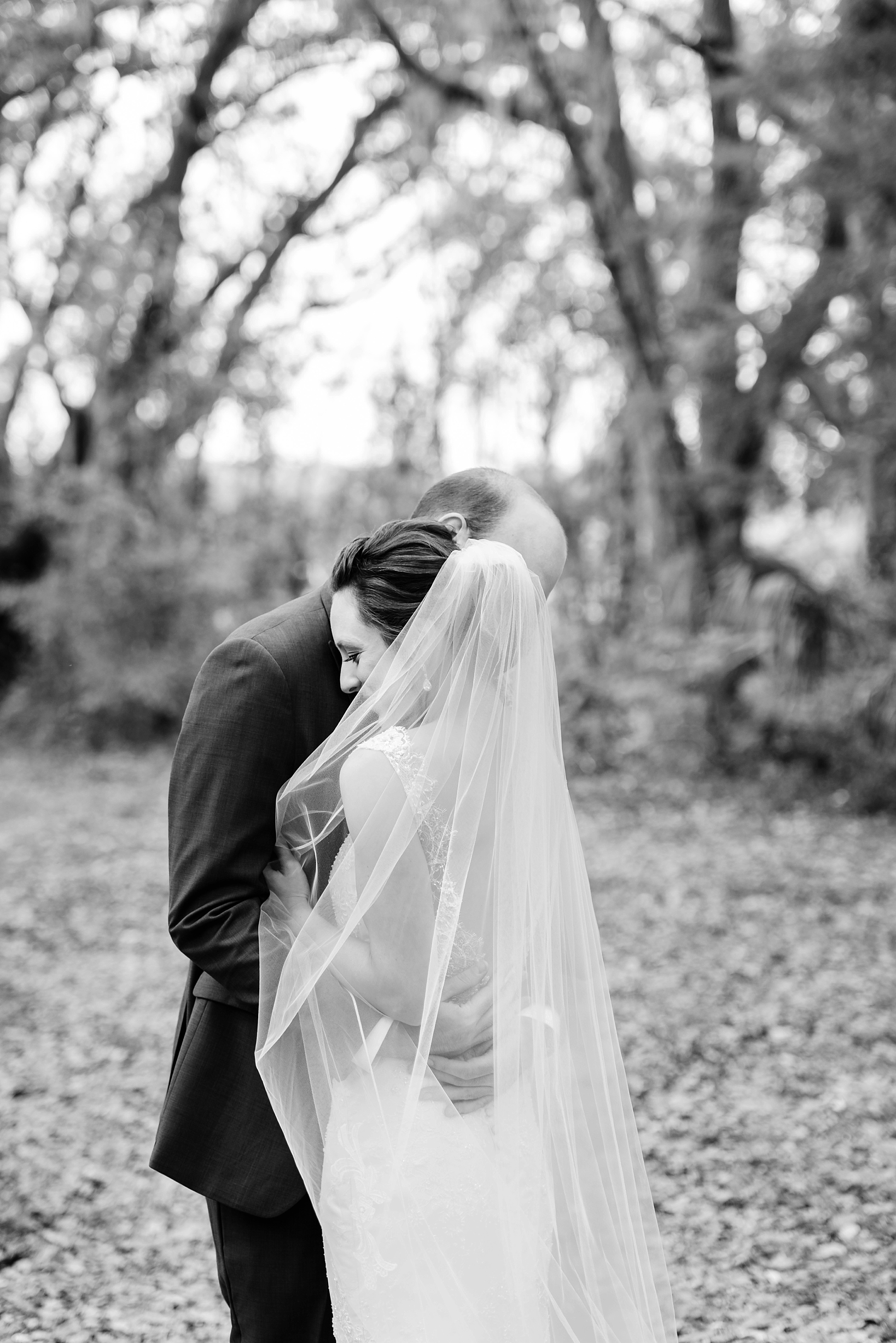 Bride and groom embracing in a timeless black and white photo by Sarah & Ben Photography