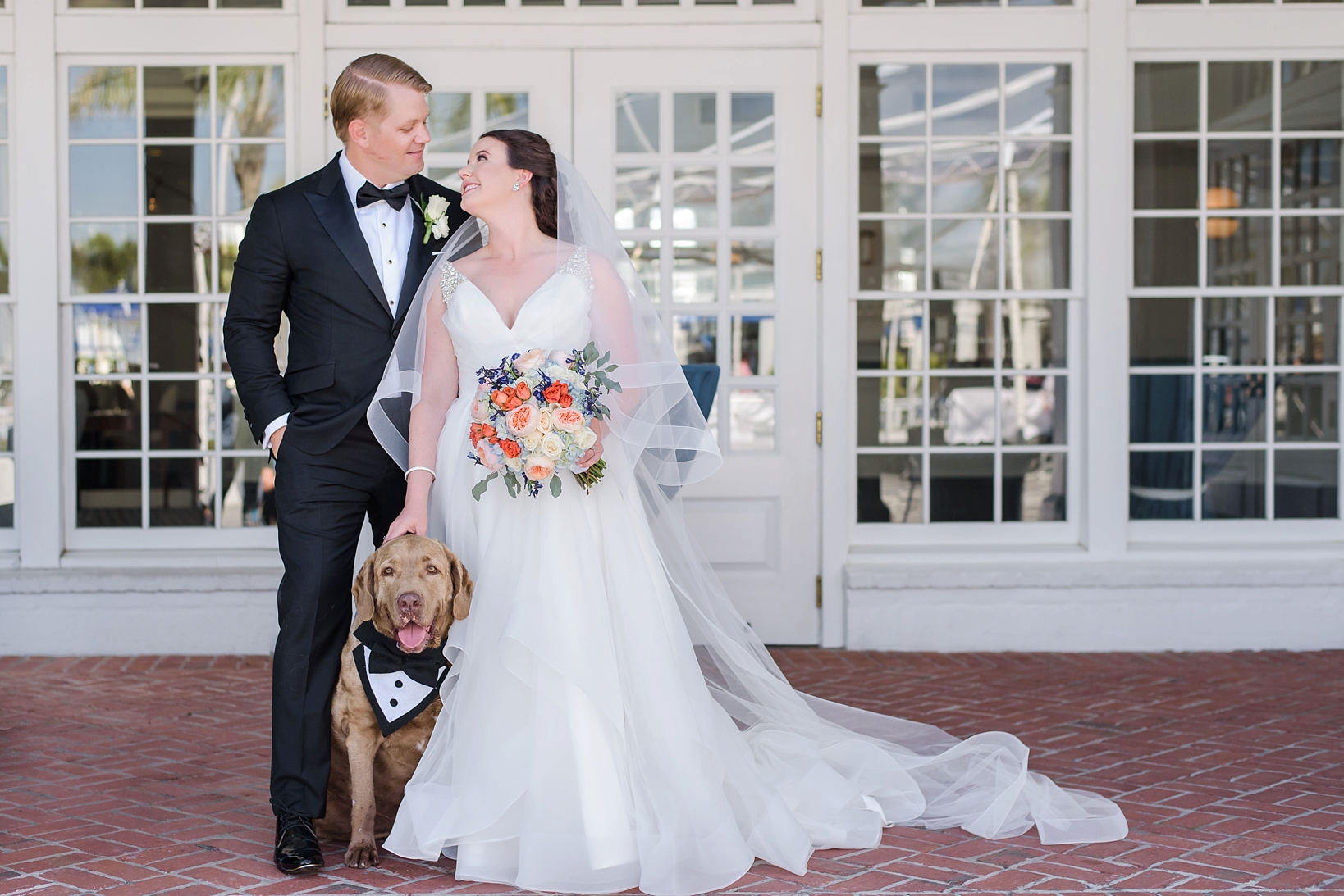 Bride and Groom pose with their dog on their wedding day