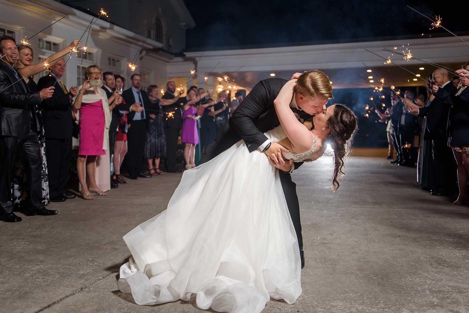 Groom dipping Bride during their sparkler send off by Sarah & Ben Photography