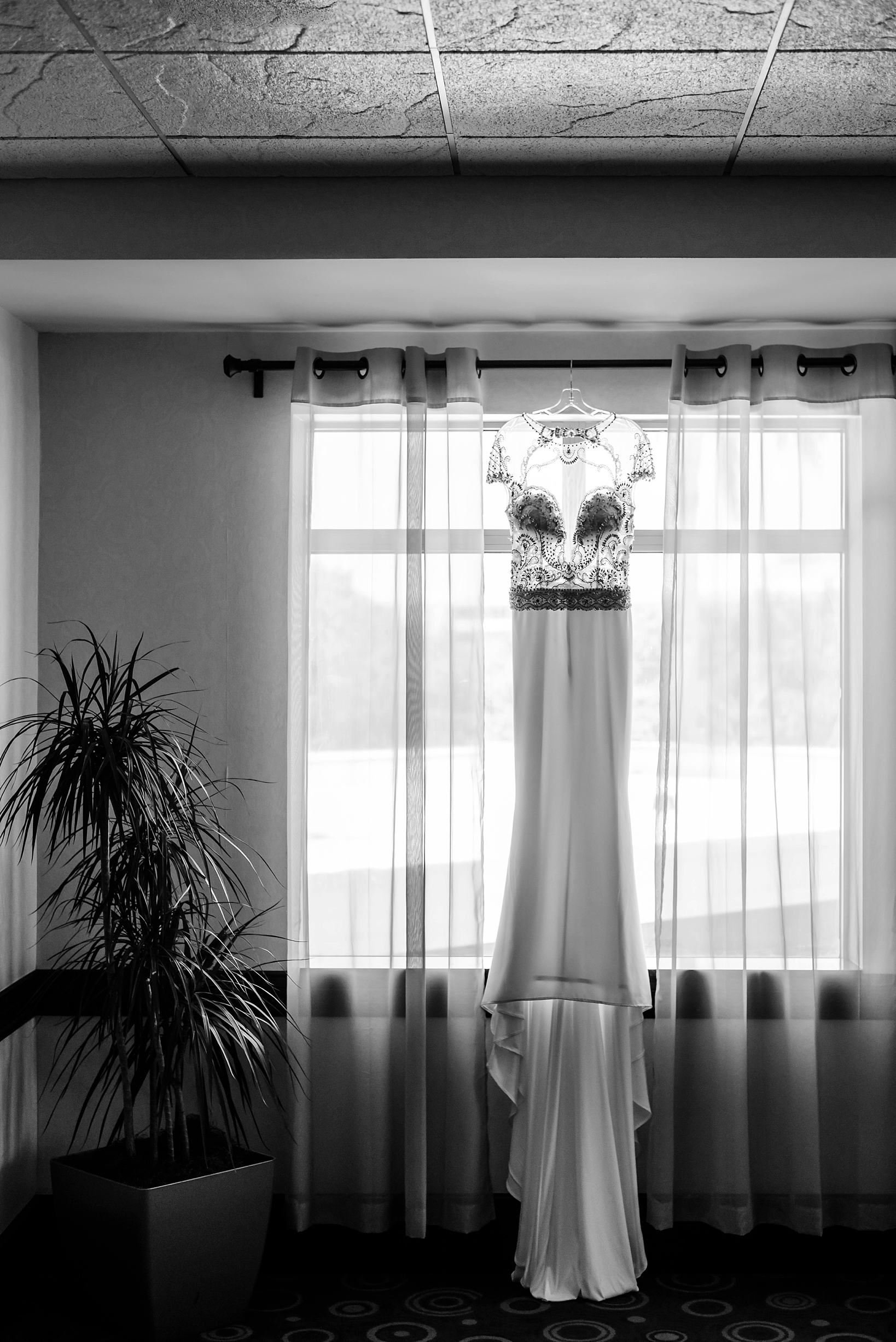 Black and White image of the wedding dress hanging in a window