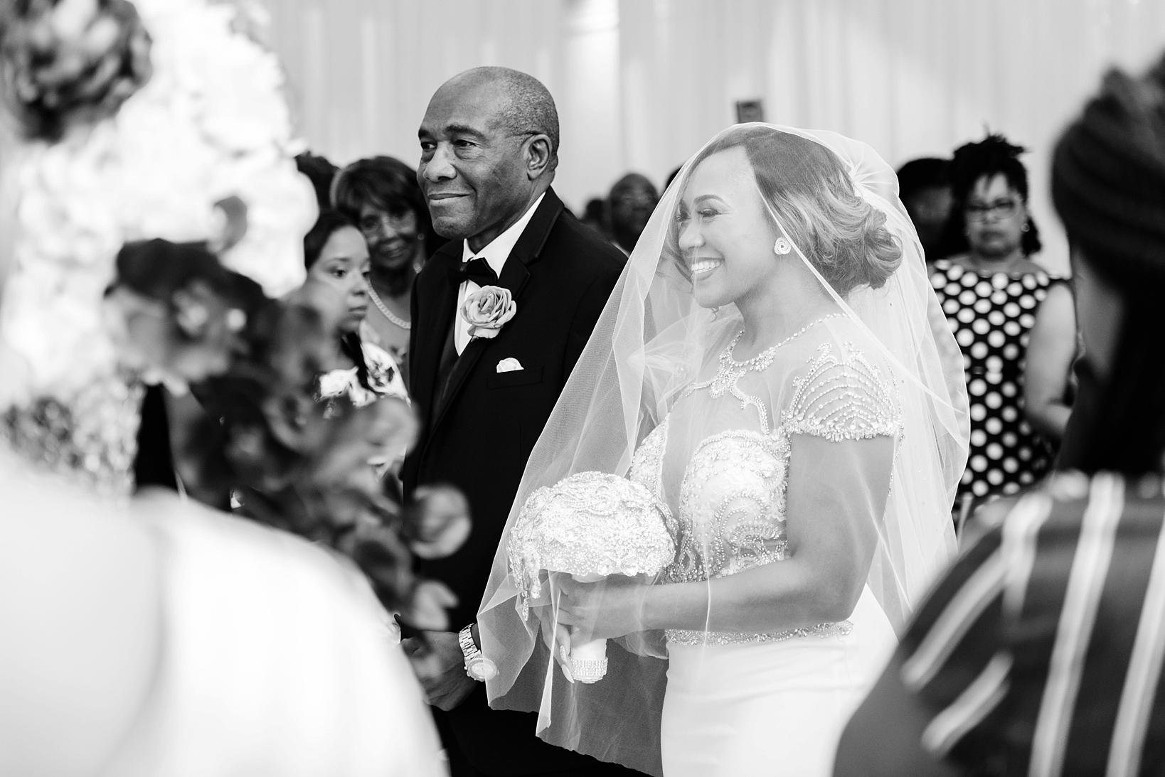 The bride smiling from ear to ear as she walks down the aisle with her Dad