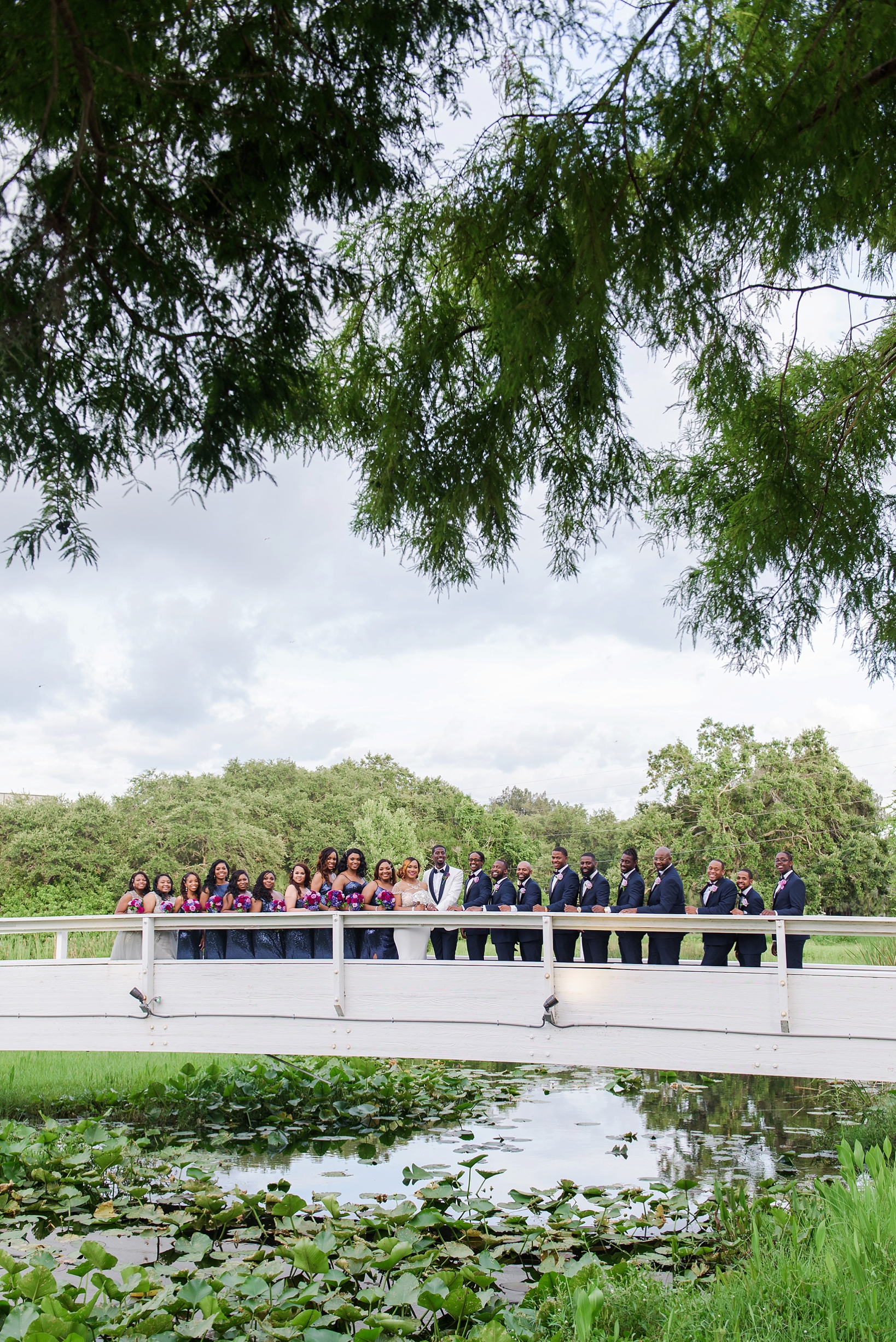The whole bridal party on a bridge near the ceremony space