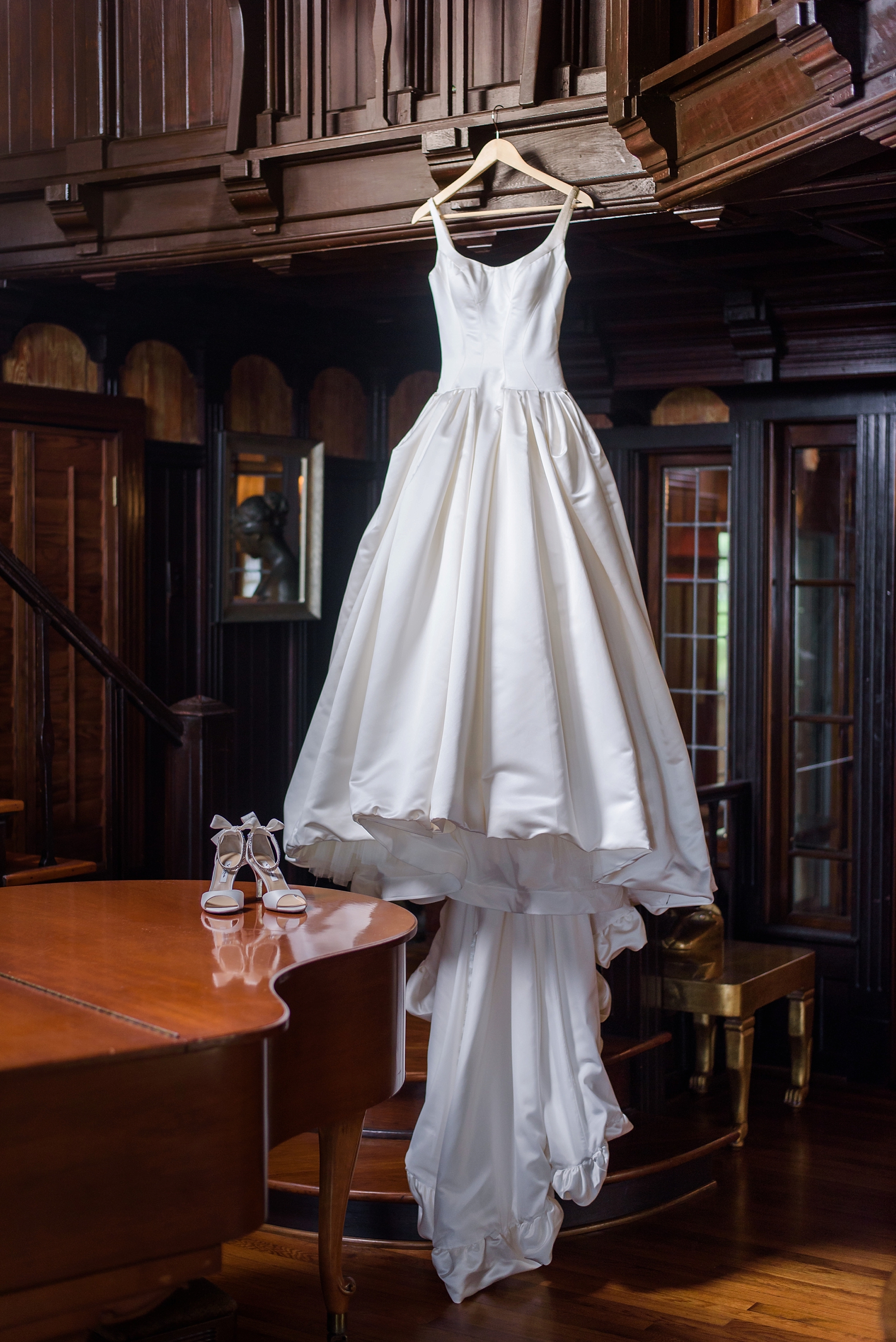 The beautiful wedding dress hanging in the private study of the estate on the halifax by Sarah & Ben Photography