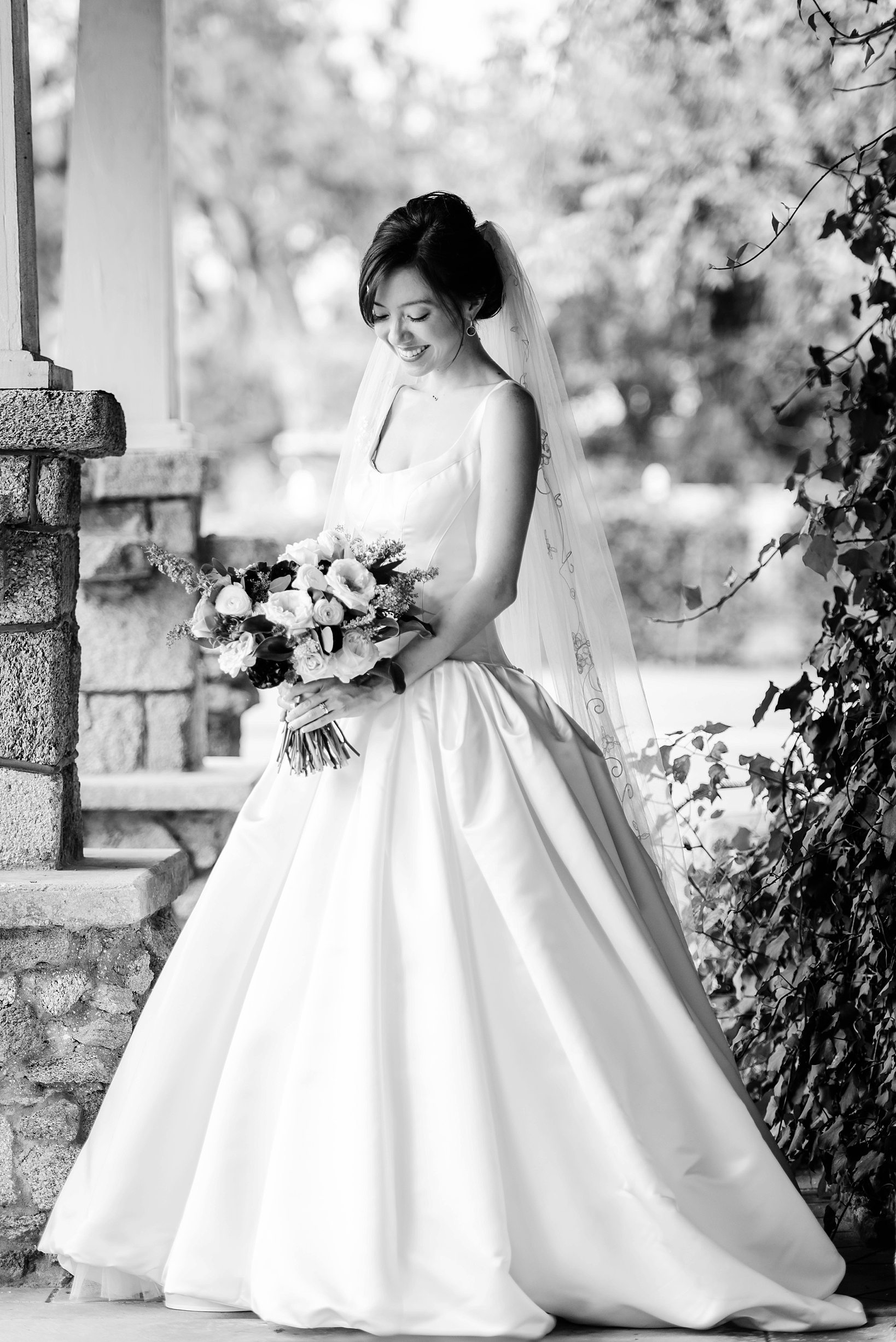 Black and white image of the bride holding her flowers looking absolutely classic by Sarah & Ben Photography