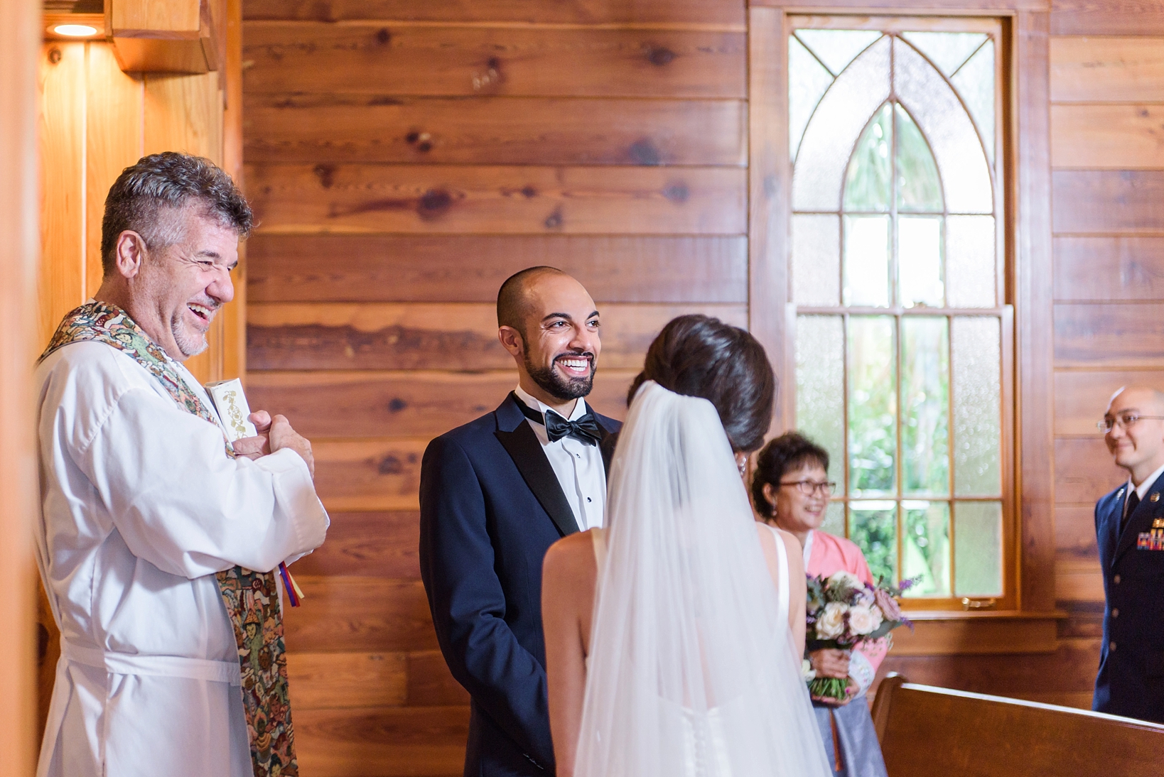 Groom smiling at his bride during the wedding ceremony by Sarah & Ben Photography