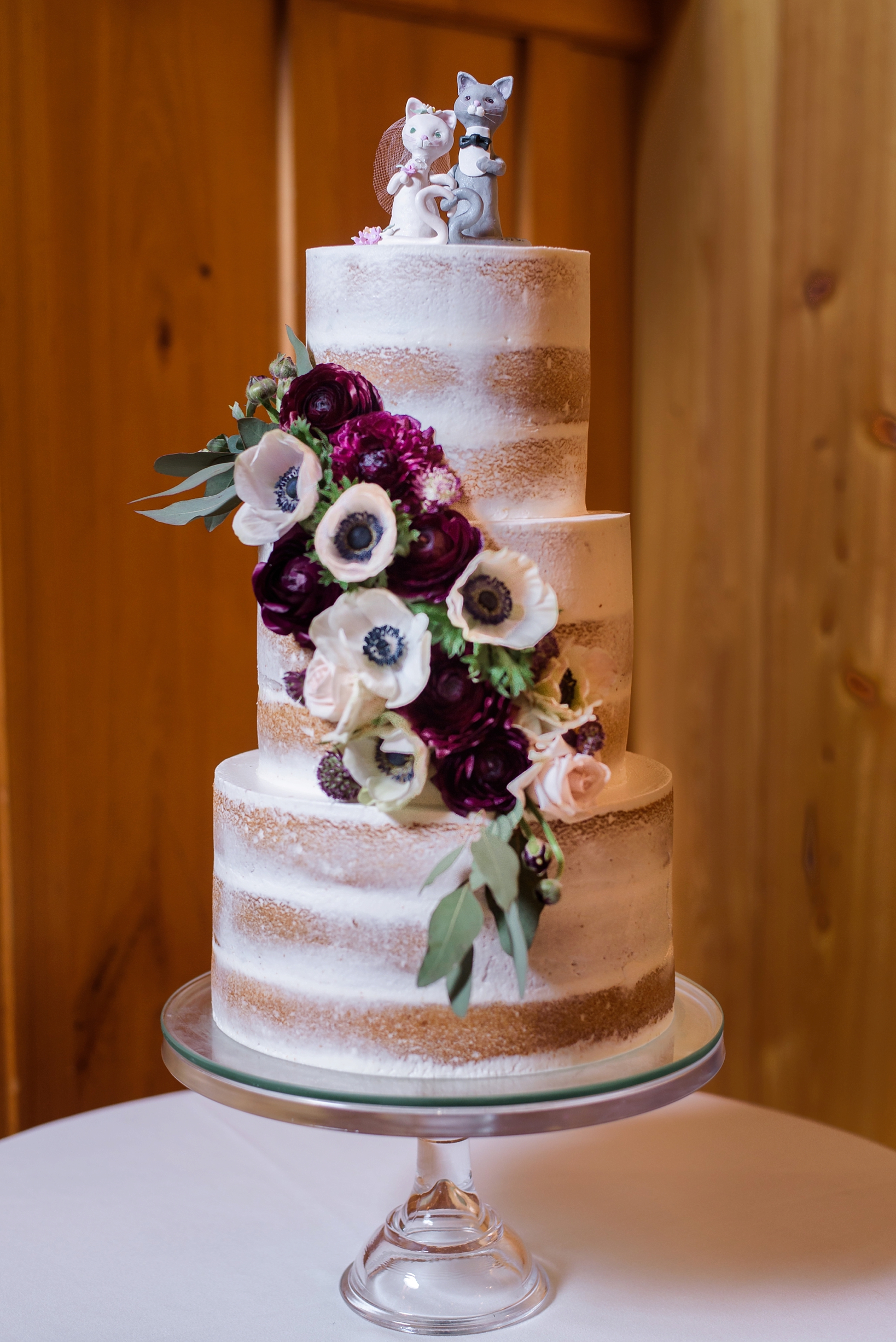 The naked wedding cake featuring custom cat themed wedding toppers by Sarah & Ben Photography