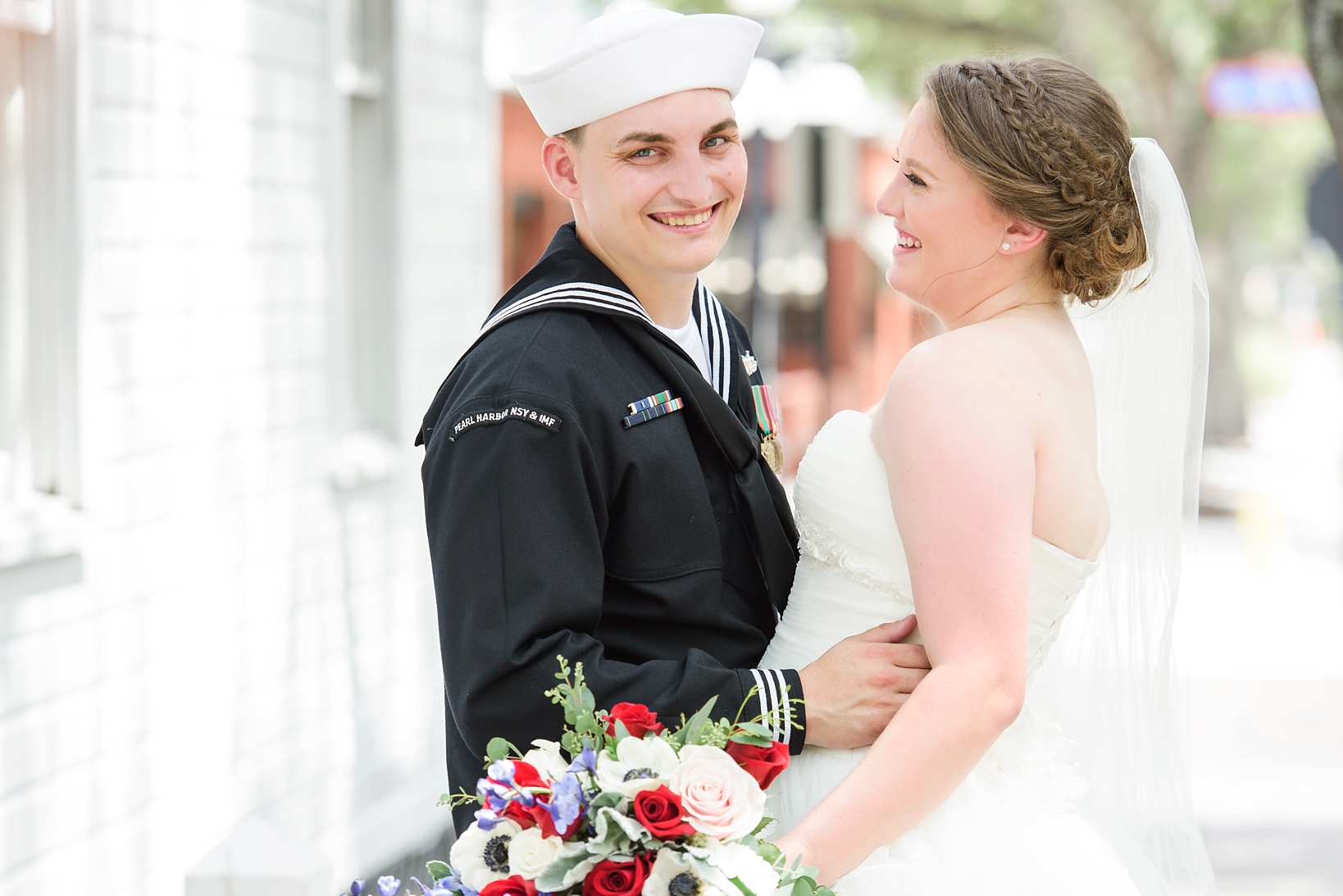 Groom in his military uniform smiles as his bride laughs on