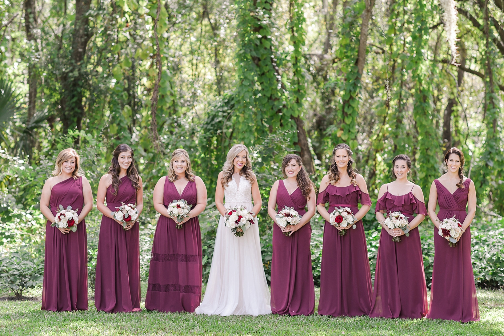 The Bride with her Bridesmaids holding bouquets surrounded by greenery at bakers ranch