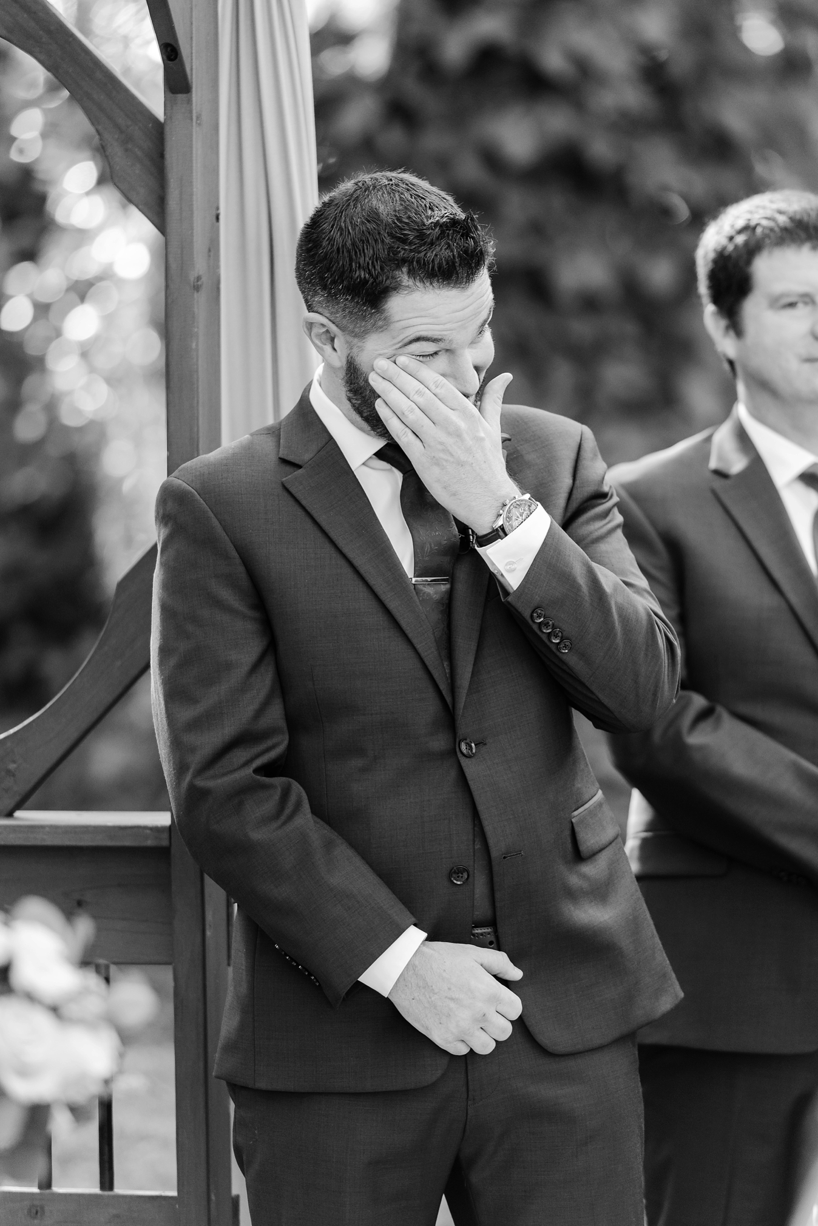 Groom wipes away a tear of joy seeing his Bride walk down the aisle by Sarah & Ben Photography located in Tampa, FL