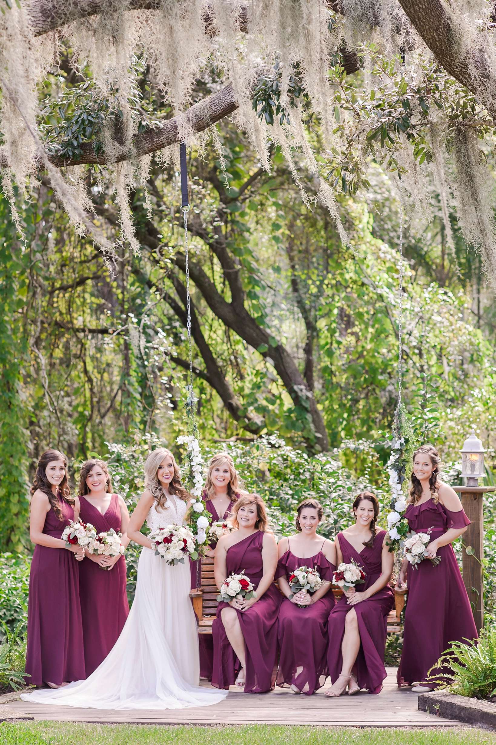 Bride and her Bridesmaids pose near a bench swing by Sarah & Ben Photography located in Tampa, FL