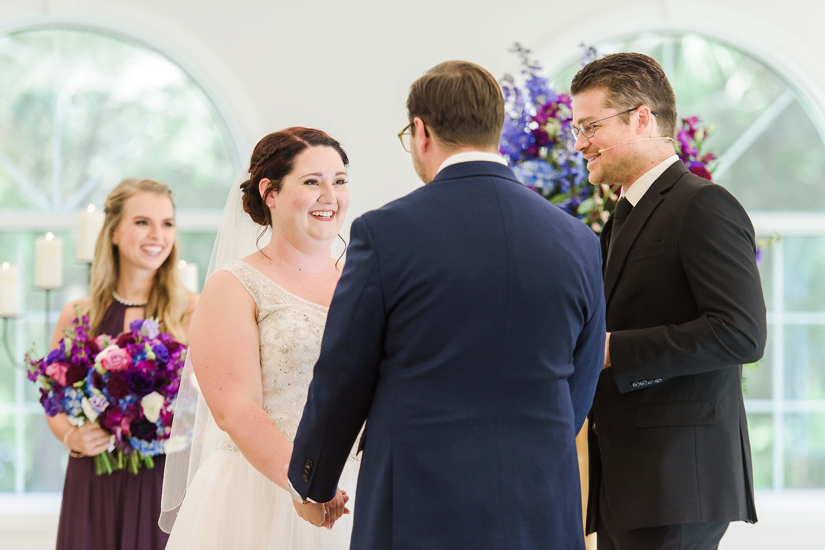 Bride and groom smiling at each other while they exchange vows by Sarah & Ben Photography