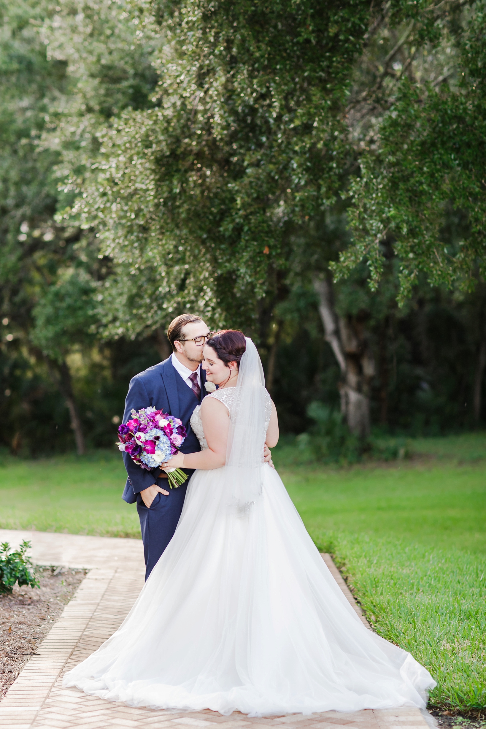 A beautiful wedding couple sharing a nice moment under the oak trees of the chapel grounds by Sarah & Ben Photography