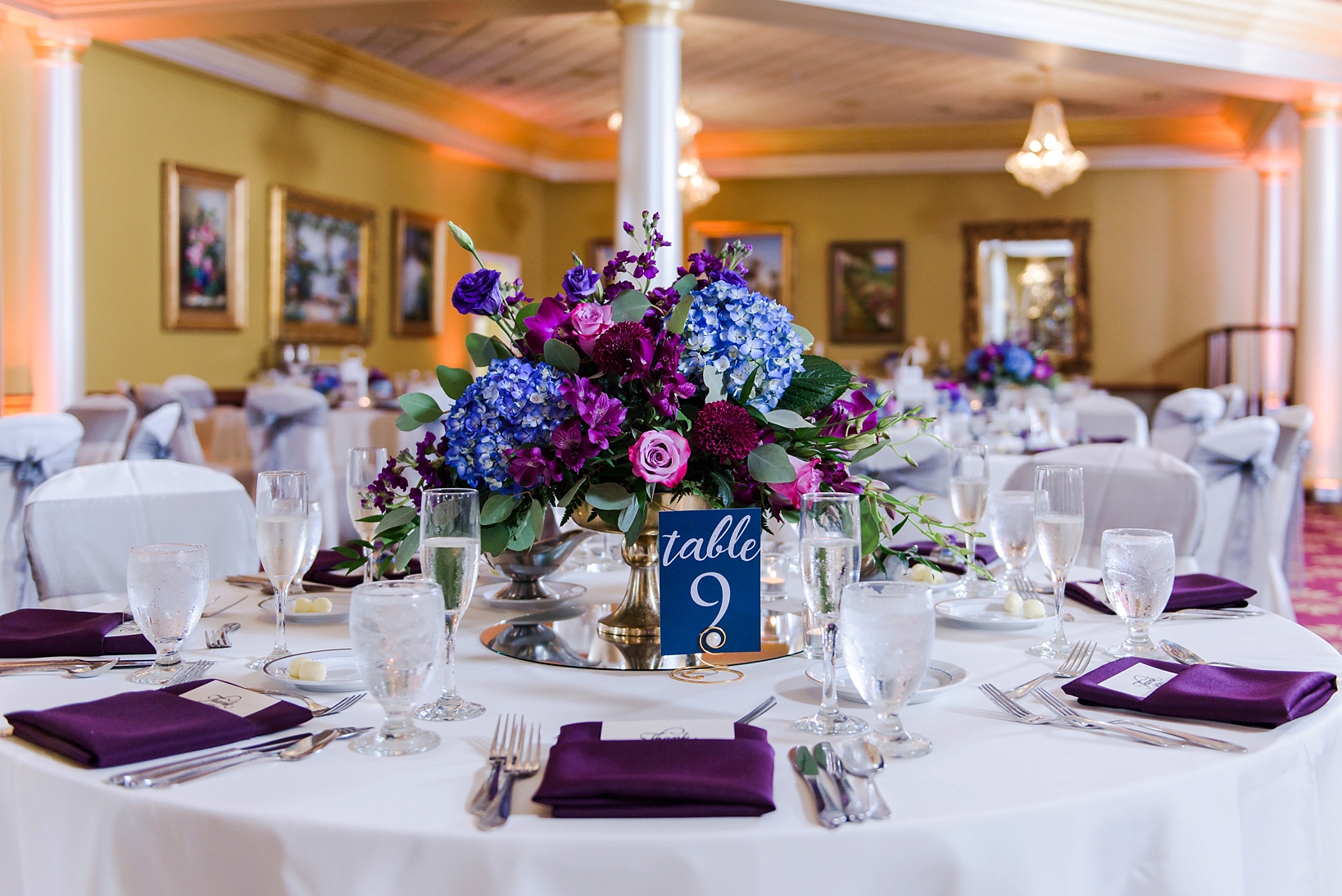 Table centerpieces with gold vase and colorful flowers by Sarah & Ben Photography