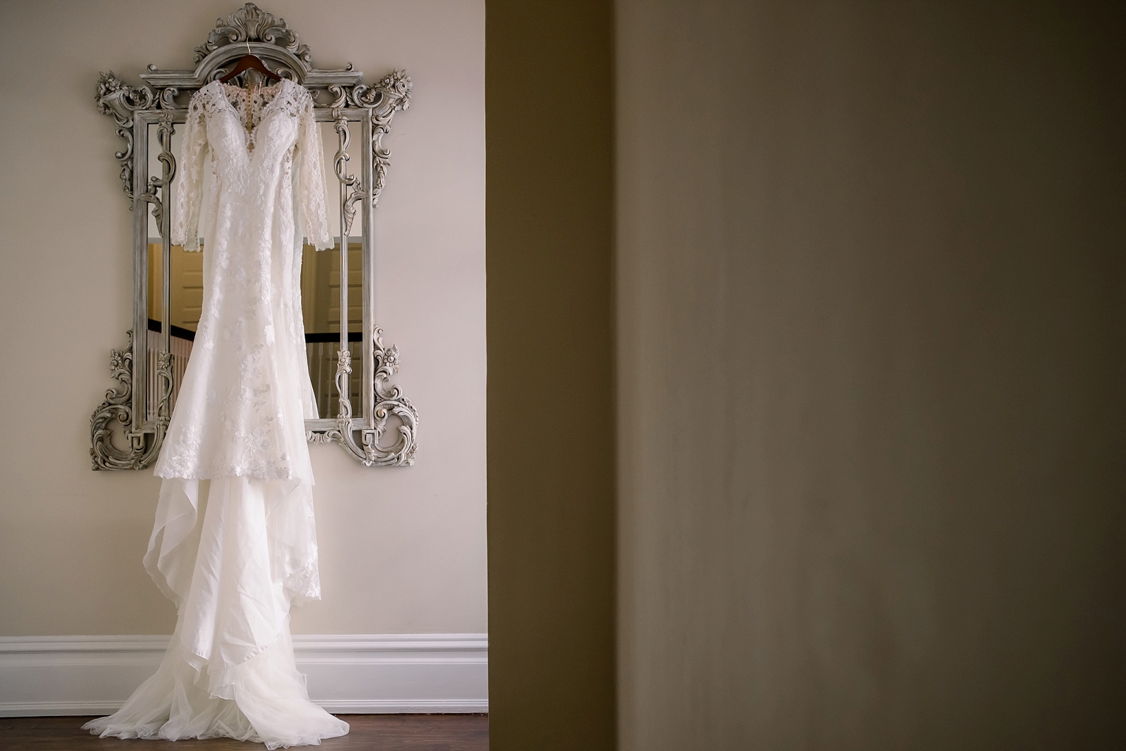 Beautiful lace wedding dress hanging on an ornate mirror in tampa Florida