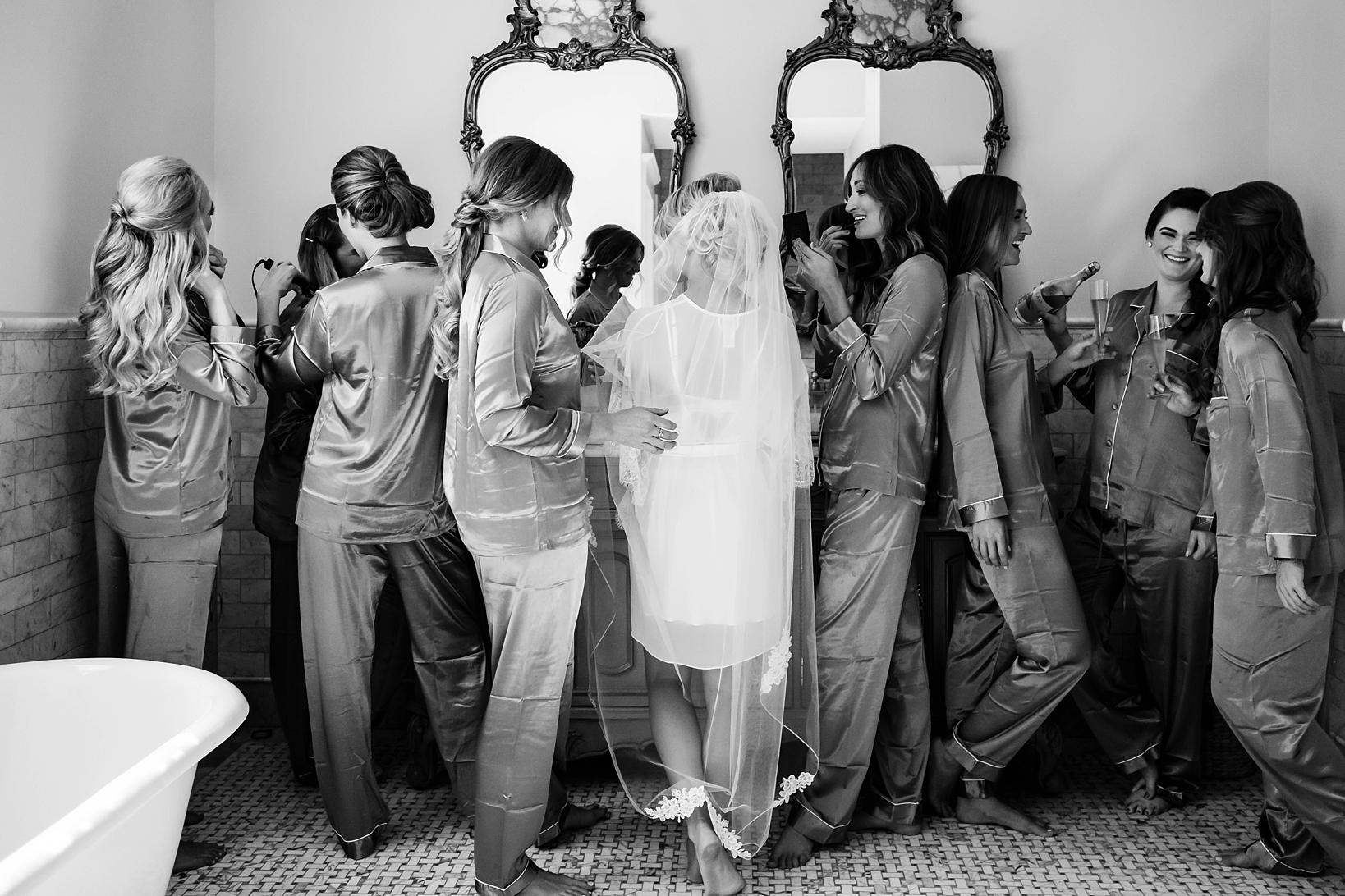 Classic black and white image of a bride and her bridesmaids getting ready for the wedding ceremony by Sarah & Ben Photography