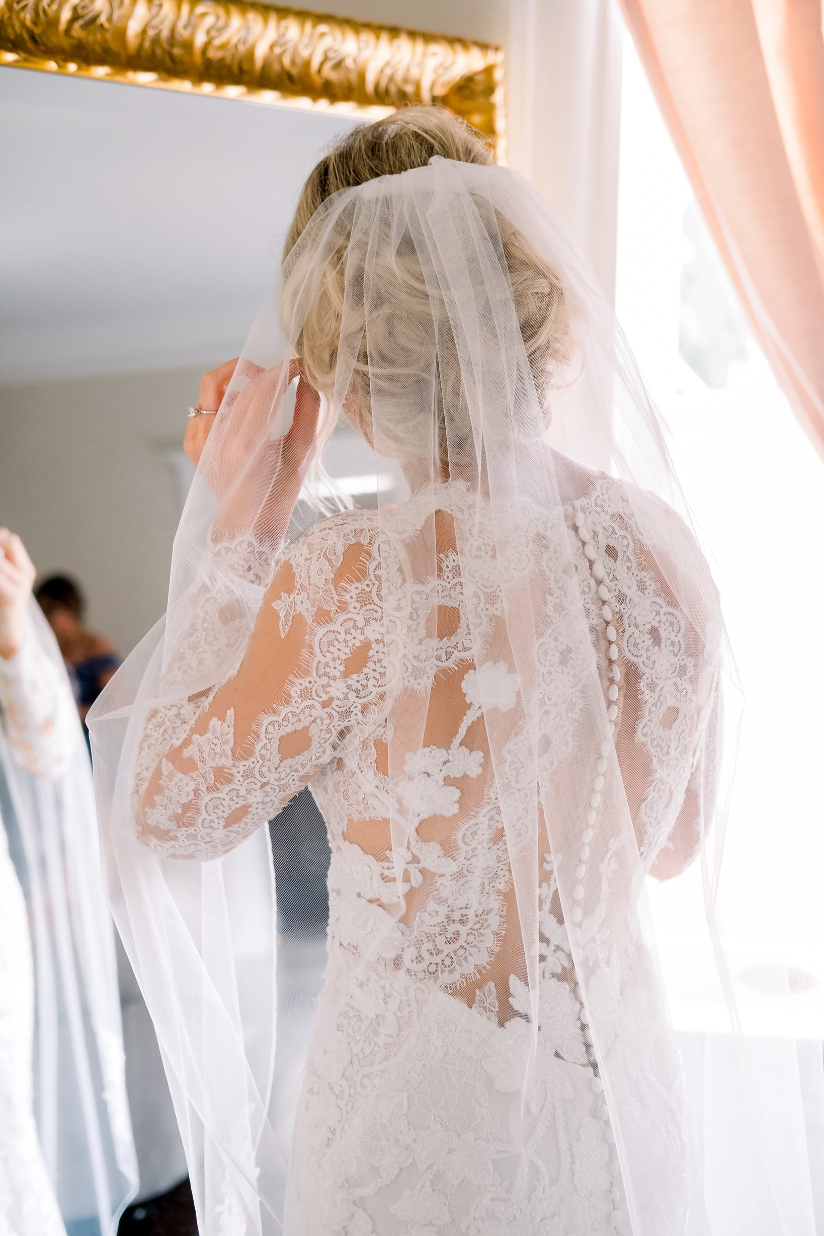 Back lace detail of the bride's dress by Sarah & Ben Photography