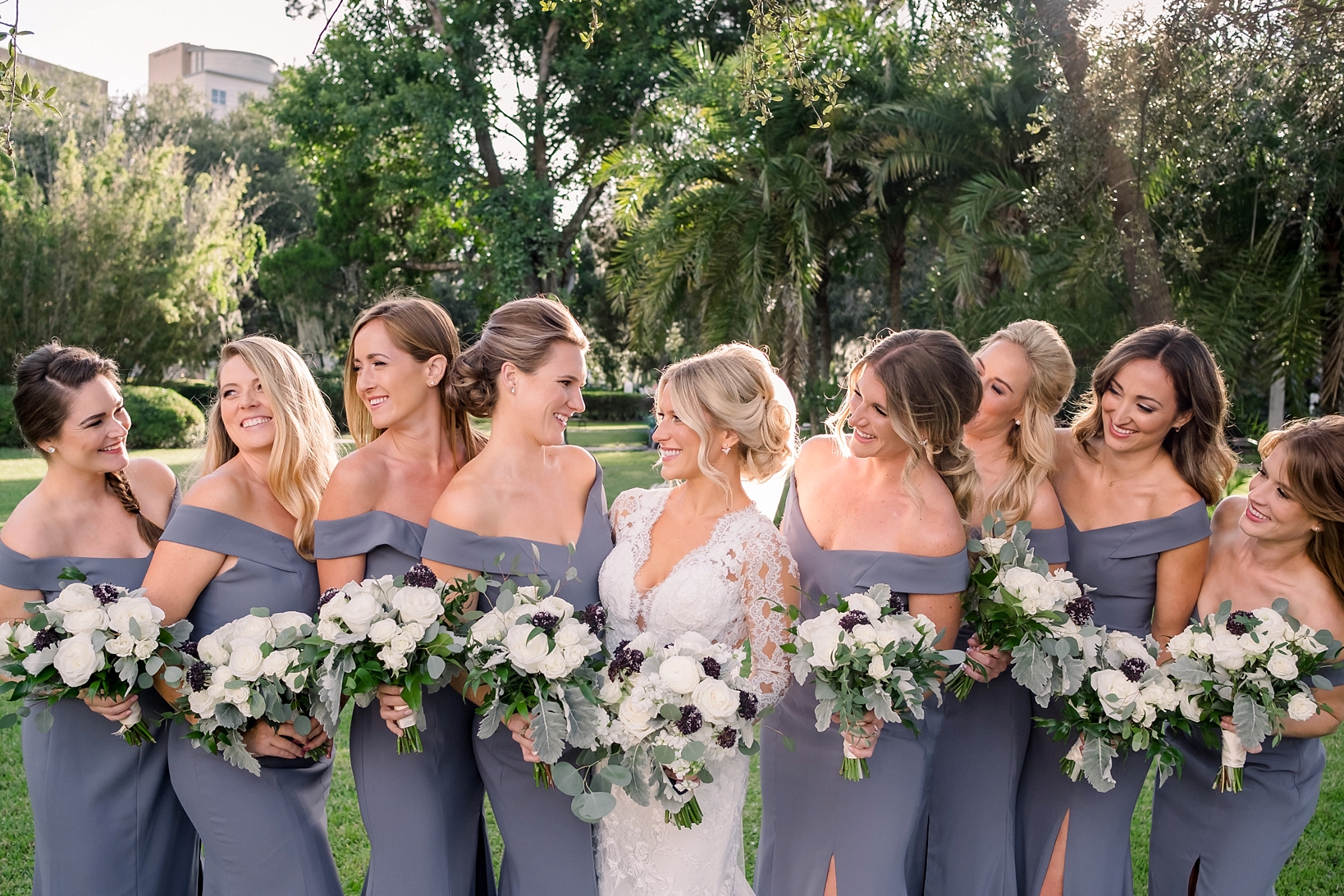 The Bride and her Bridesmaids share a nice moment in the gardens of UT in Tampa, Florida by Sarah & Ben Photography