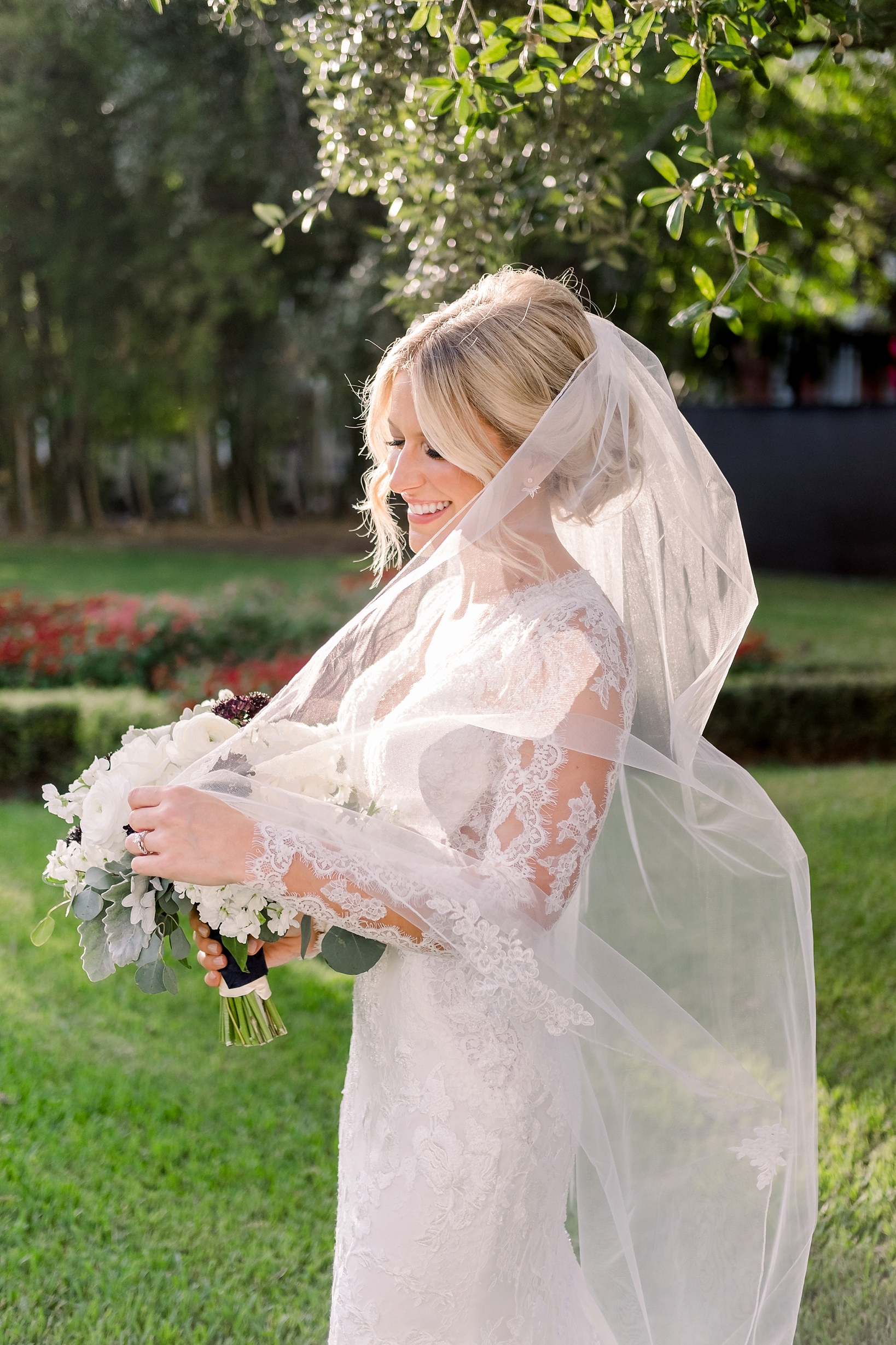 The bride caught in a candid moment with her veil by Sarah & Ben Photography
